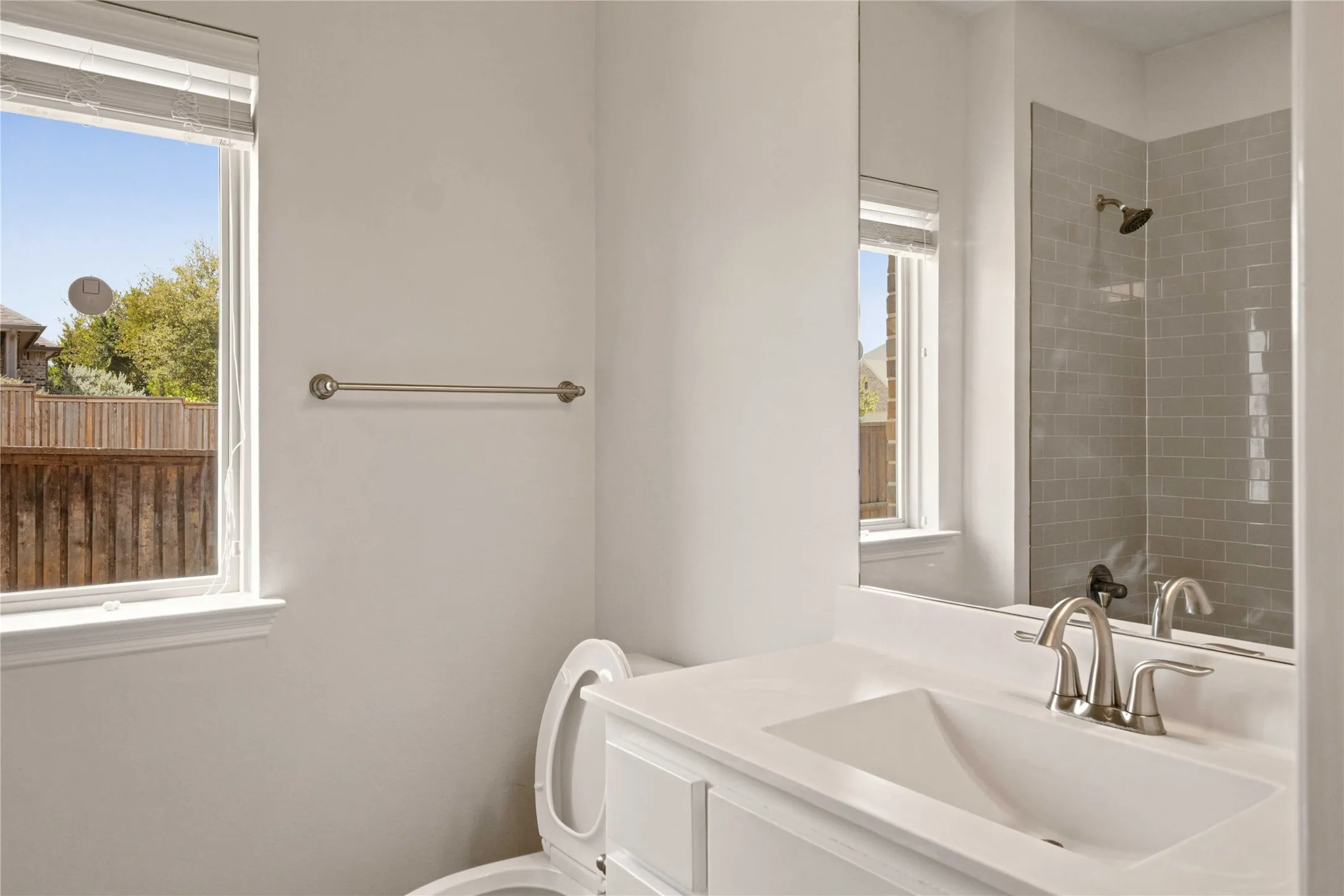 White vanity with an integrated sink, brushed nickel faucet, and a large mirror