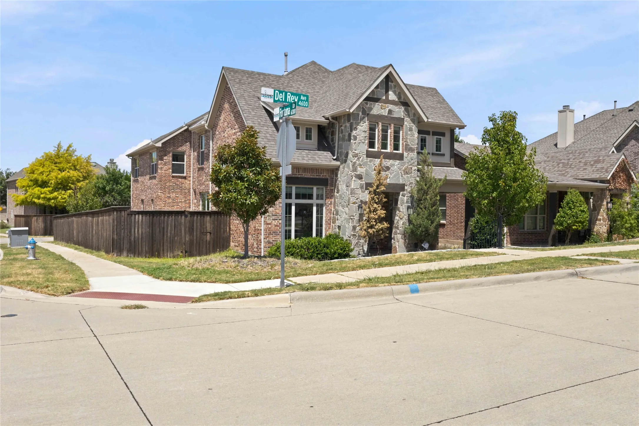 Two-story residence featuring a brick and stone exterior, multiple roof gables, and an attached two-car garage