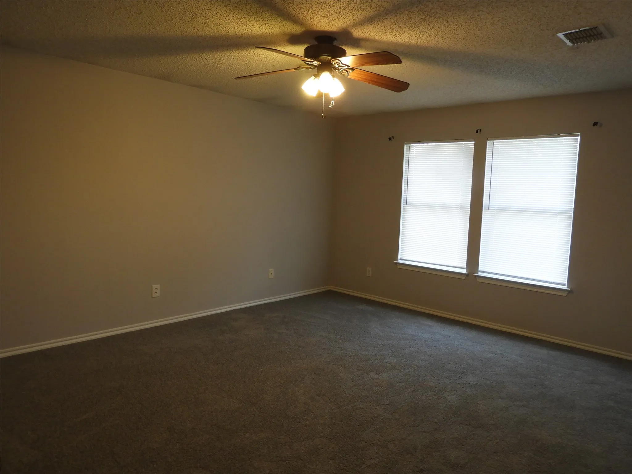 Primary Bedroom with ceiling fan and walk-in closet