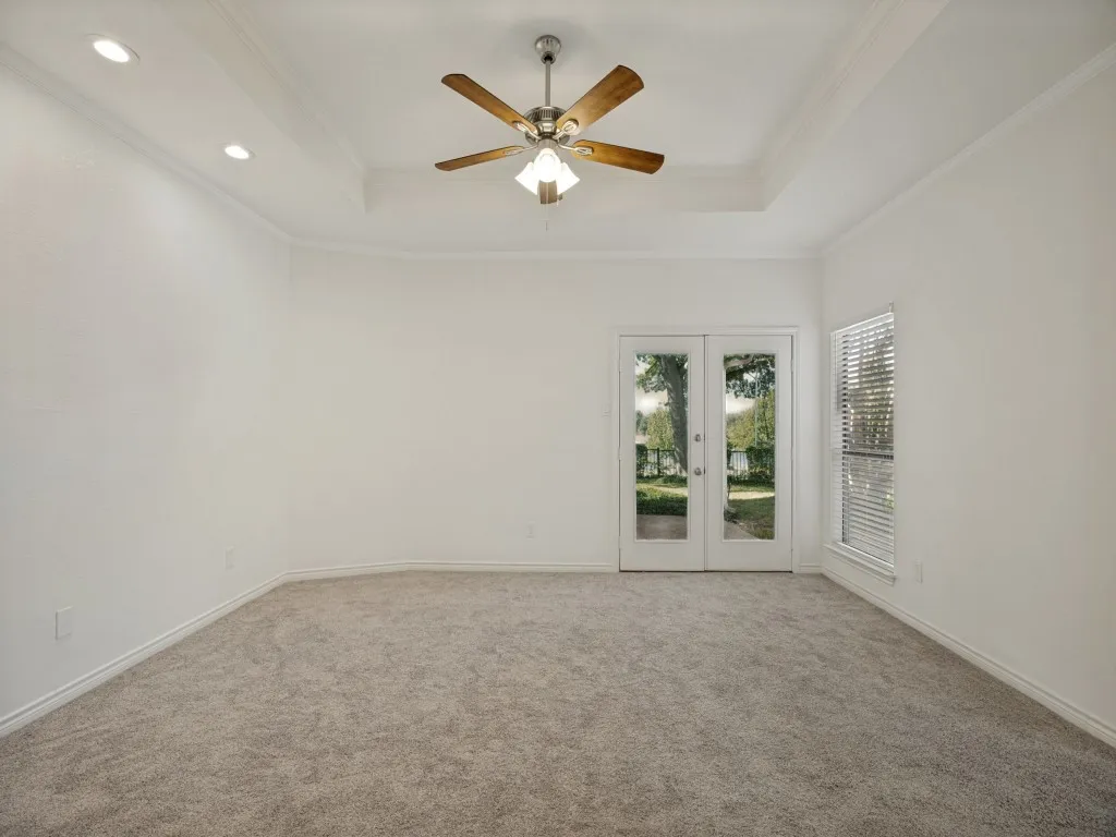 Primary bedroom with fresh paint, new carpet, recessed lighting, tray ceiling. access to back covered porch overlooking golf course.