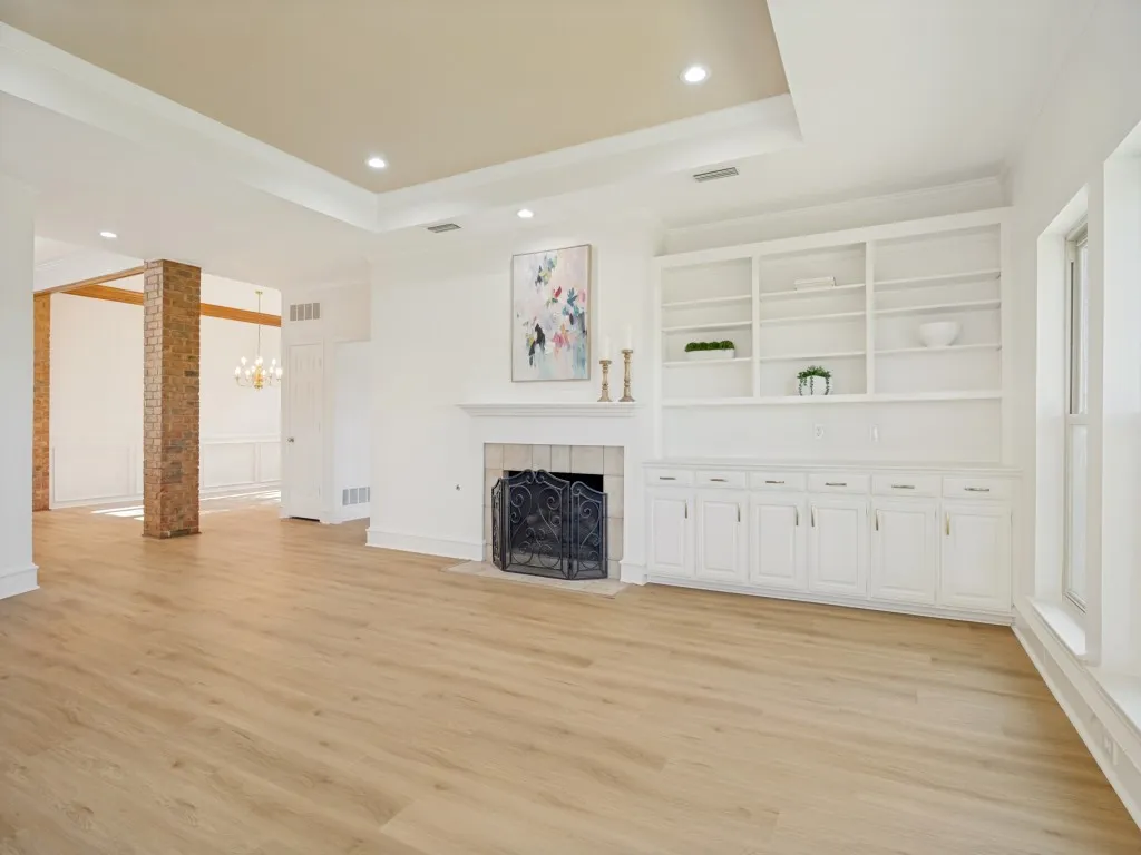 Very large living room overlooking golf course with fireplace and built in cabinetry.