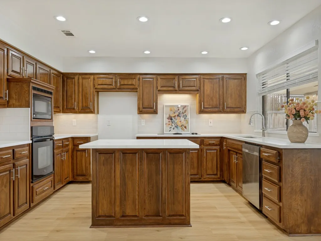 Kitchen remodeled with new island, dishwasher, stainless sink and quartz countertops.