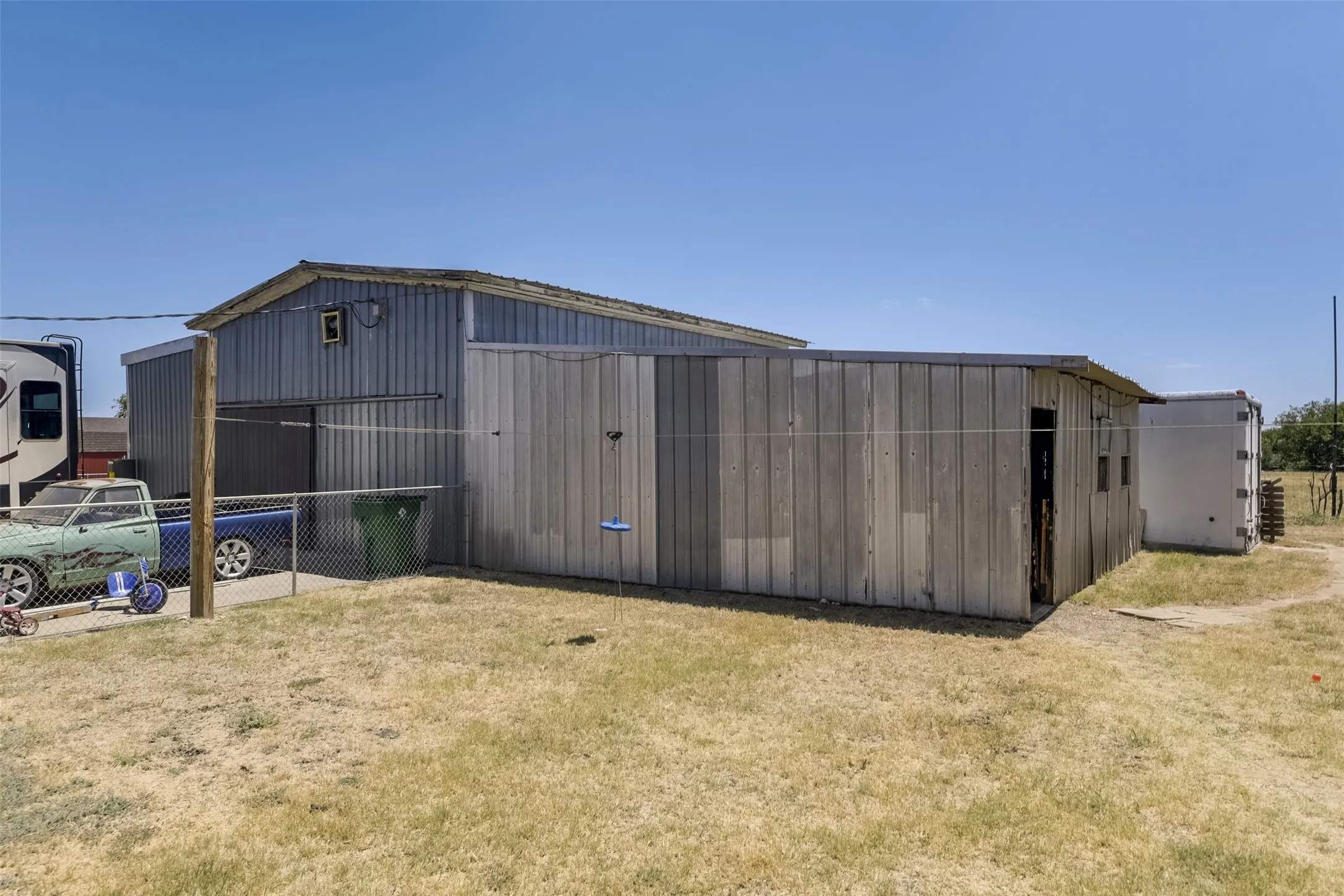 1700+sqft Metal-sided structure with a pitched roof and an additional attached shed
