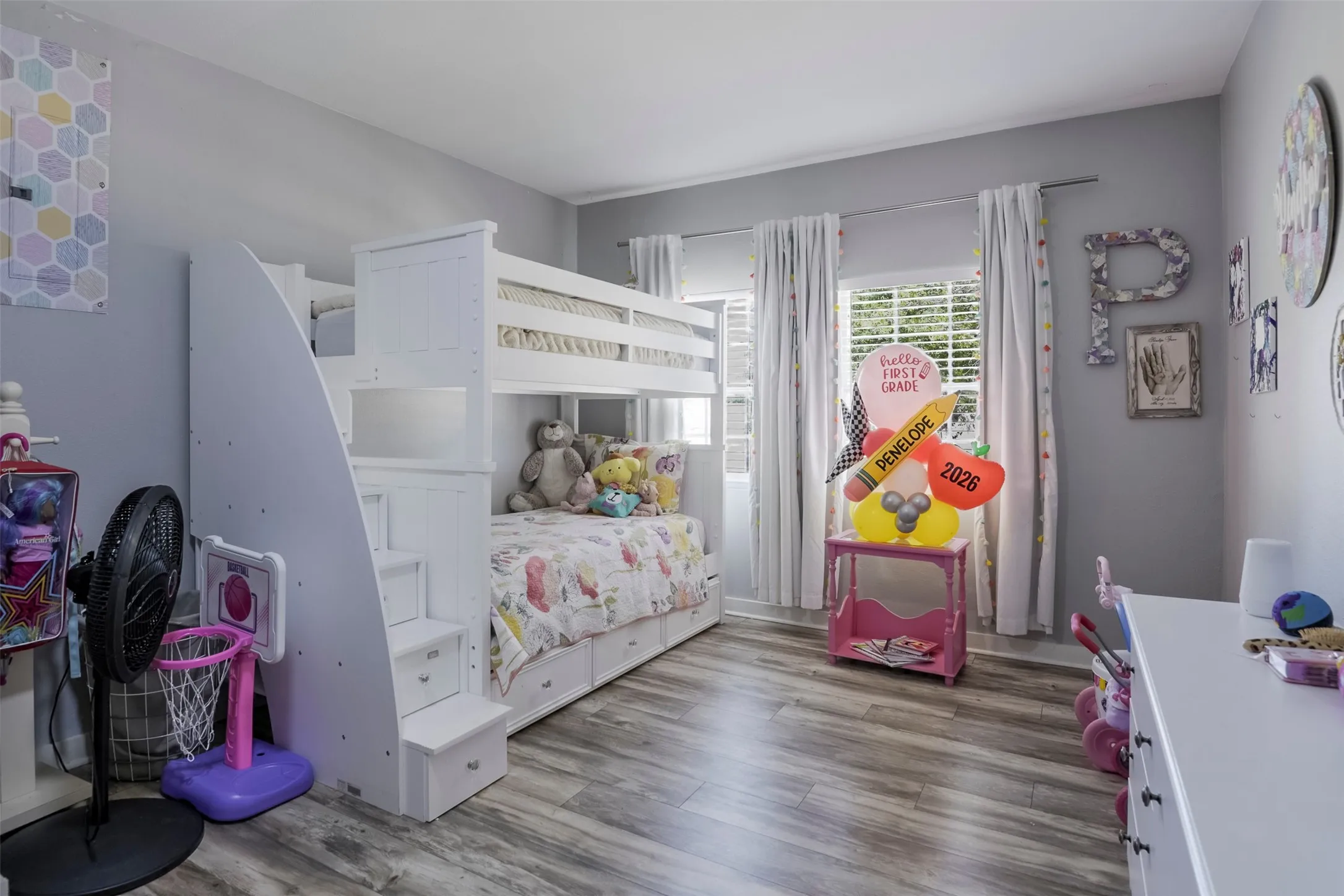 Wood-finish flooring, white bunk bed with integrated staircase, white window blinds, and light gray wall paint