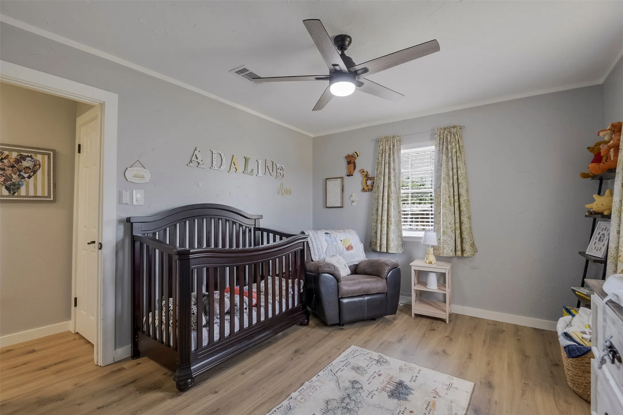 Neutral wall paint, wood-finish flooring, white trim, window with blinds, and a ceiling fan with integrated lighting