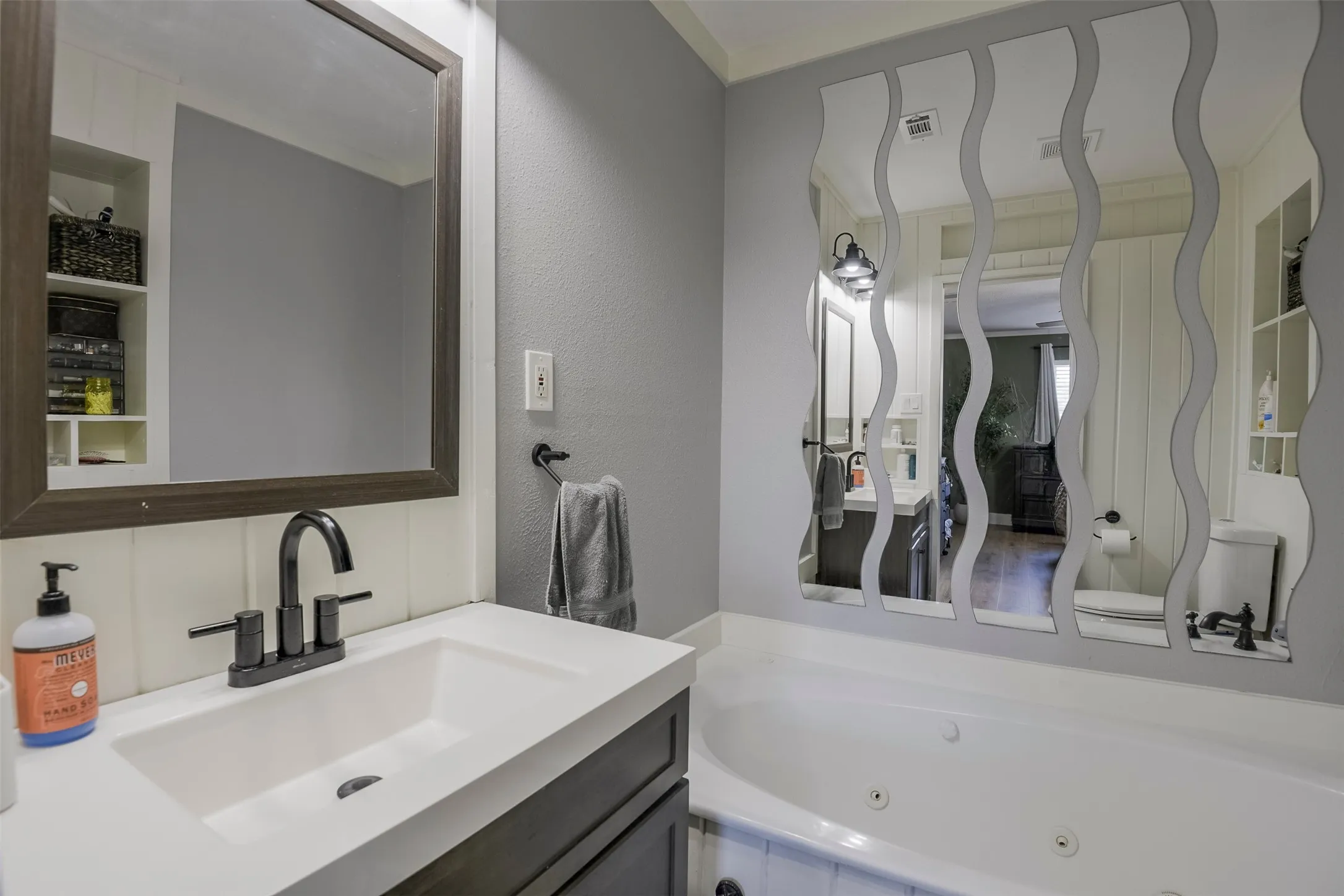 Vanity with integrated sink, matte black faucet, and built-in shelving