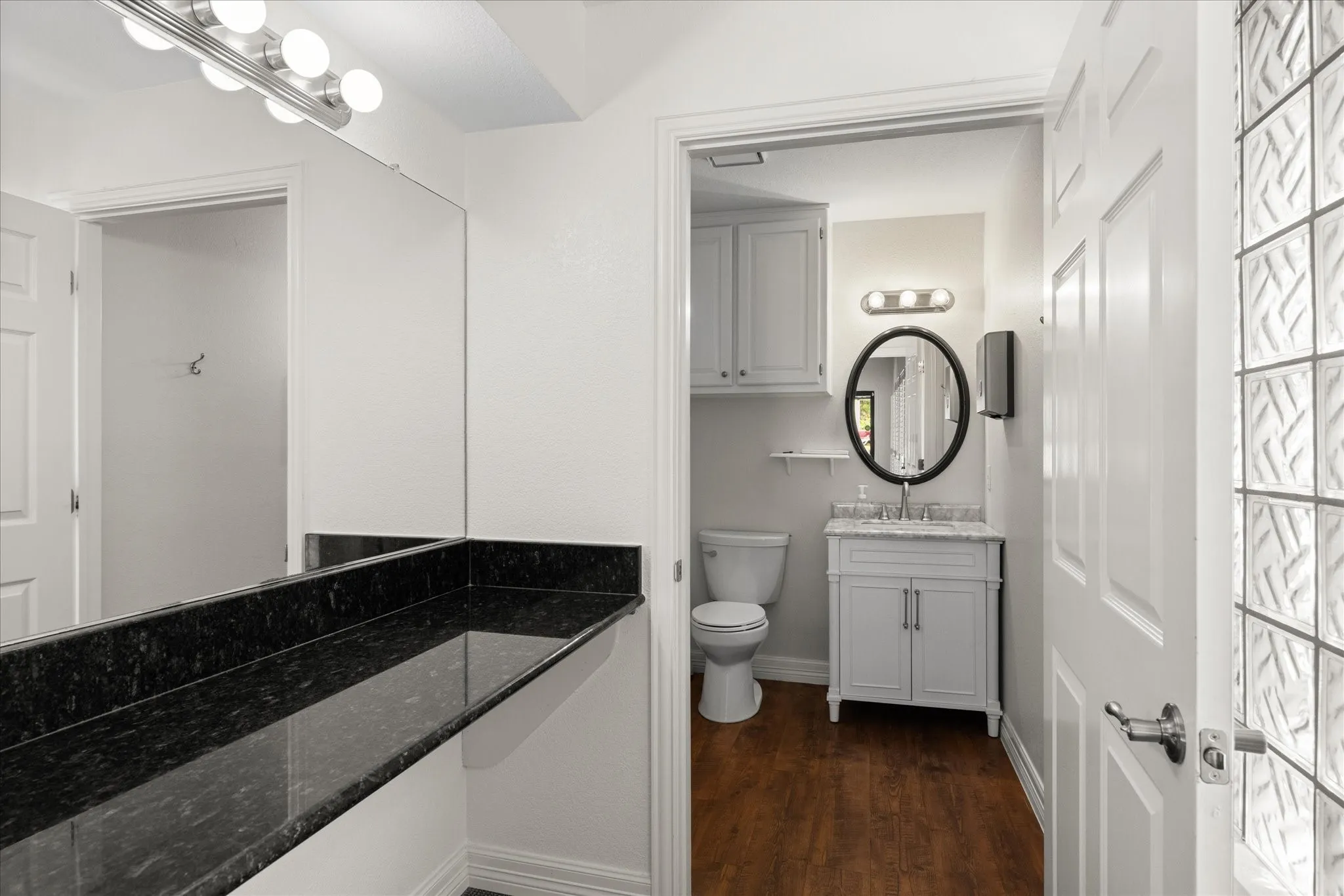 Expansive vanity with a dark countertop and full-width mirror