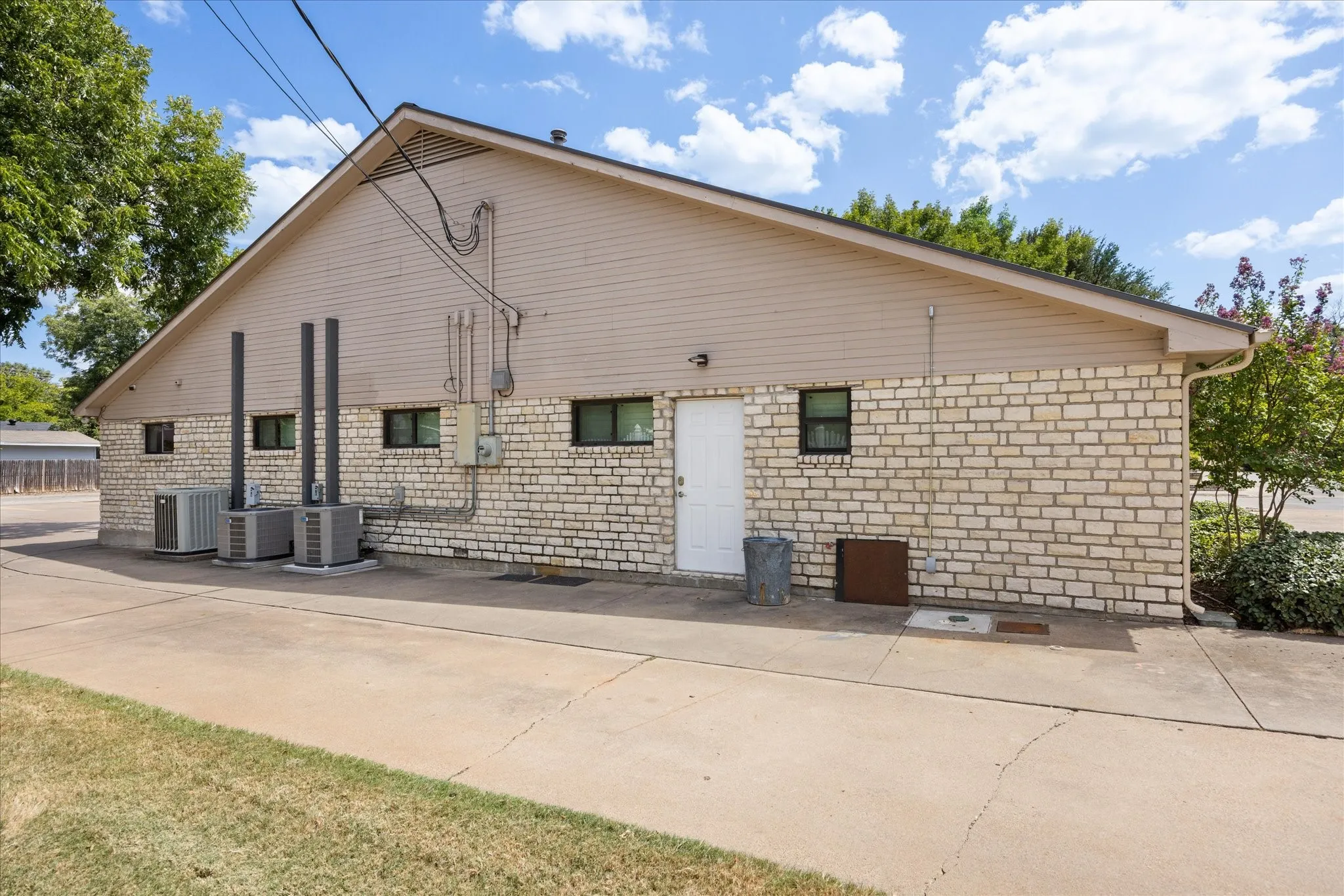 Brick and siding exterior with multiple windows and a white entry door