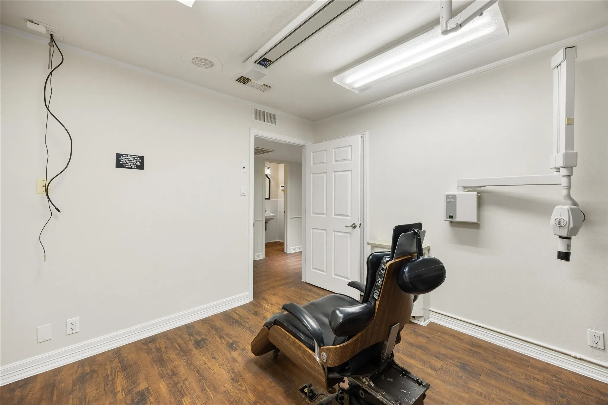 Recessed lighting, wood-finish flooring, white walls, and a white paneled door