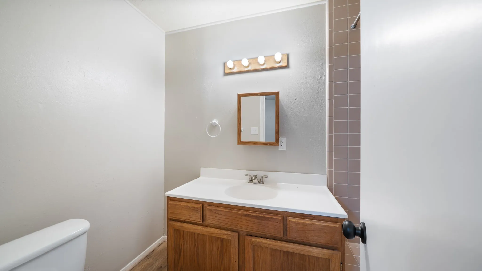 Wood-finish vanity with an integrated sink and light-colored countertop