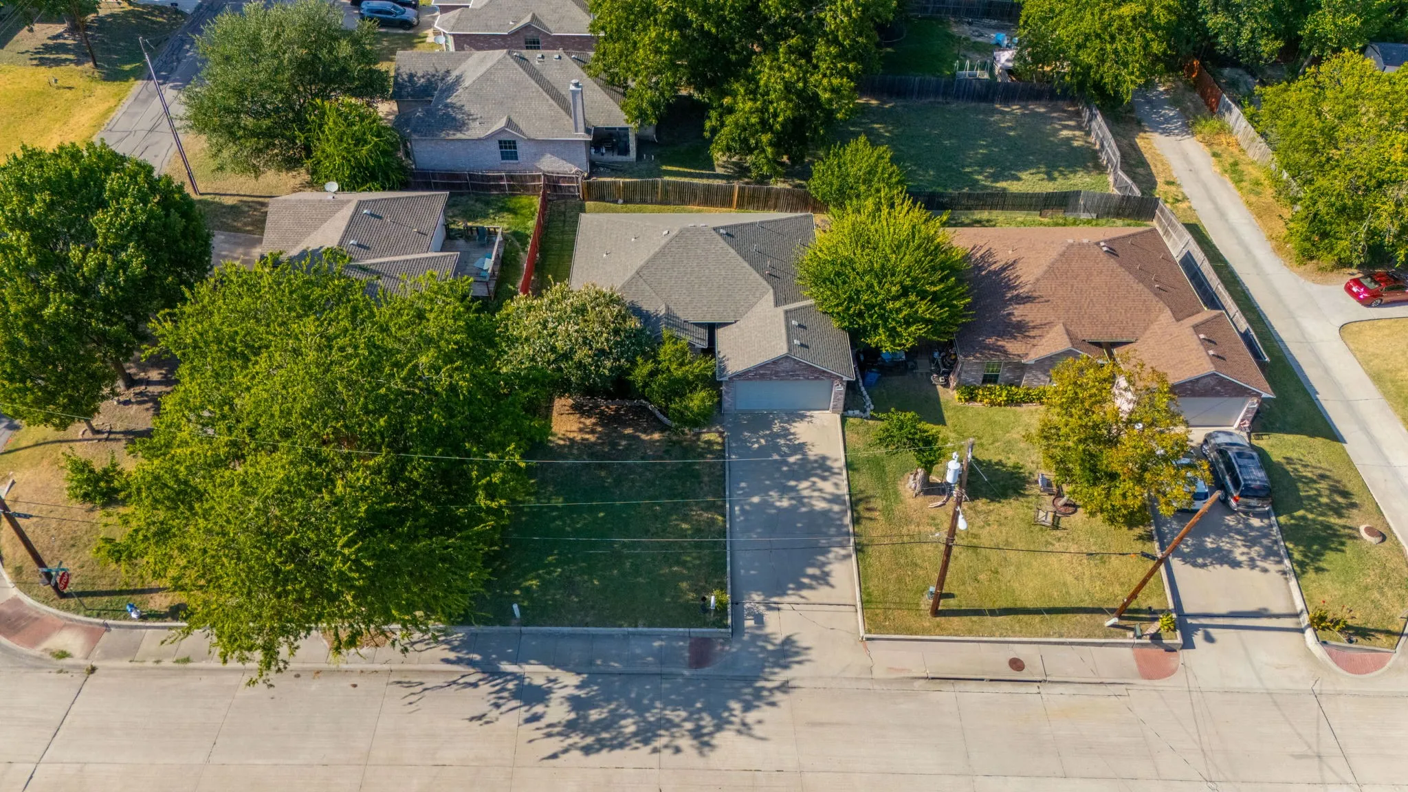 Residential property with an attached garage, paved driveway, and established landscaping
