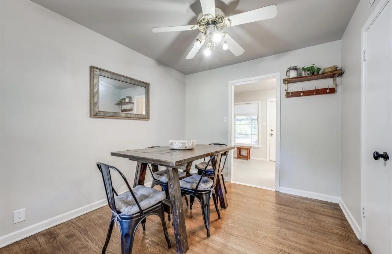 Wood-finish flooring with light gray walls, white ceiling fan, and white trim