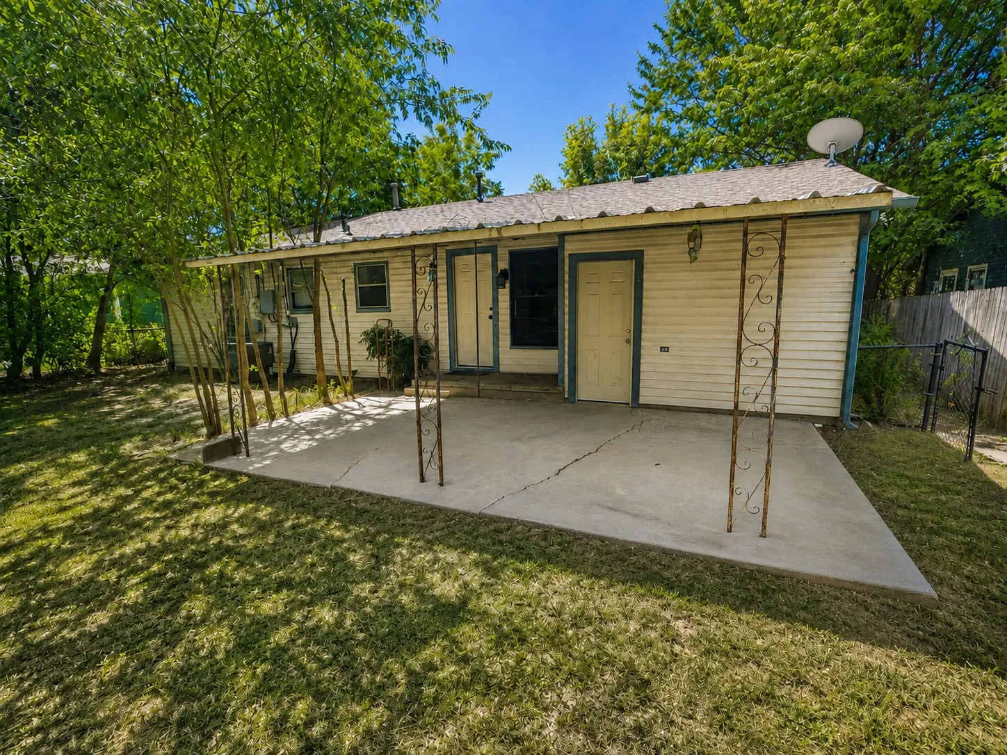 Rear patio featuring a concrete slab and overhead metal pergola