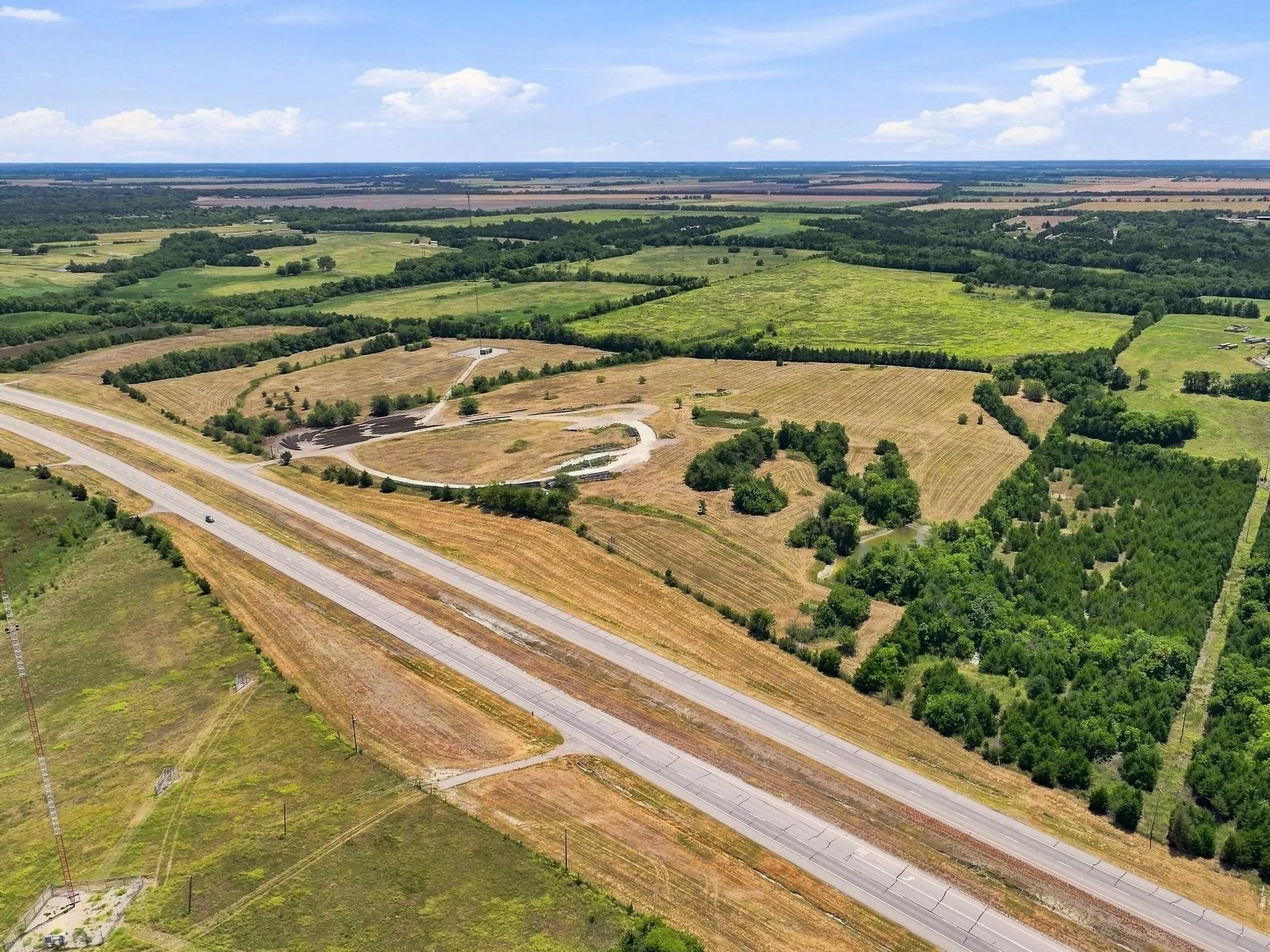 Expansive acreage featuring multiple natural ponds, mature trees, and direct road frontage