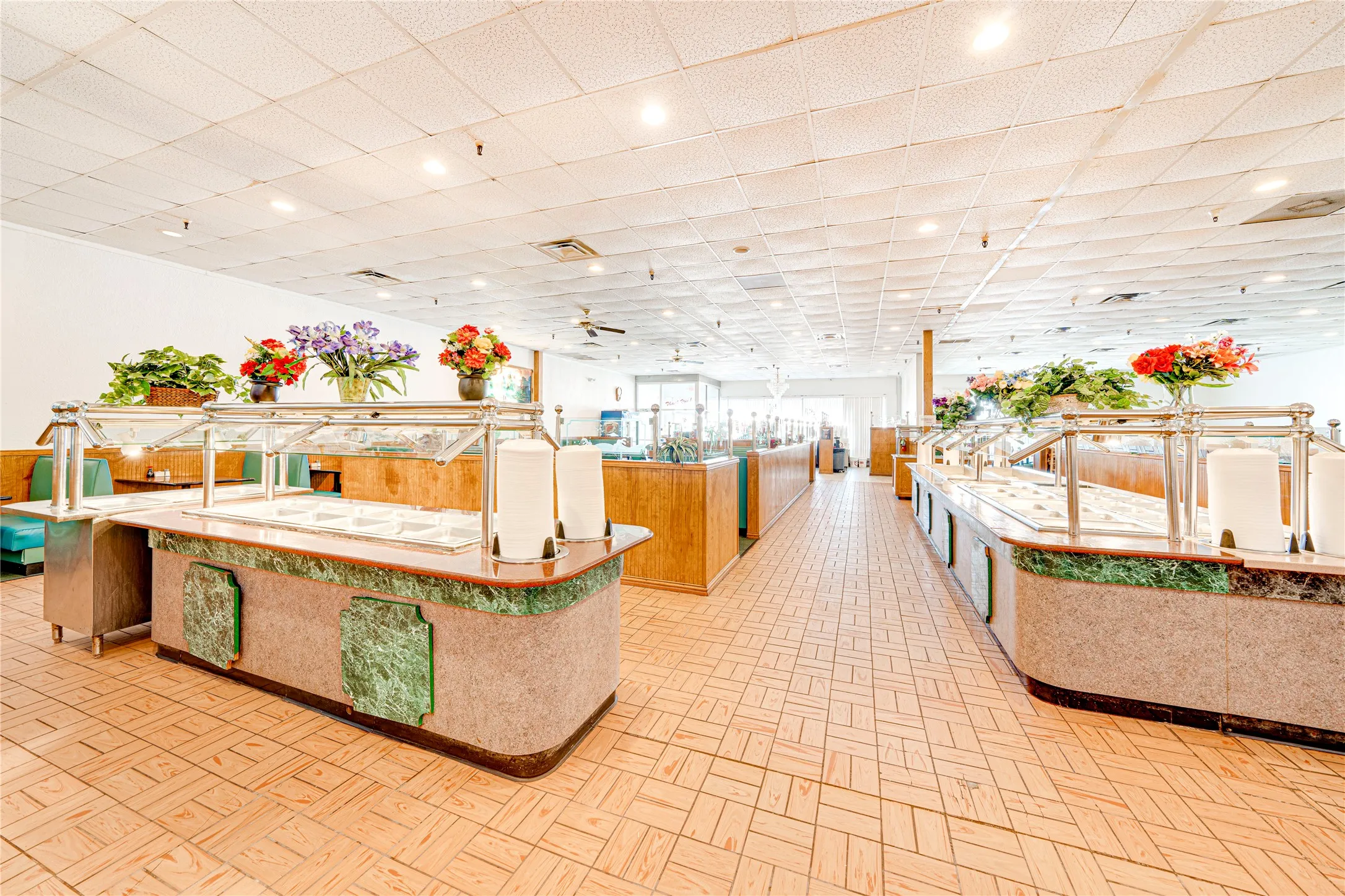 Expansive commercial interior with light-toned patterned floor tiles and a drop ceiling with recessed lighting