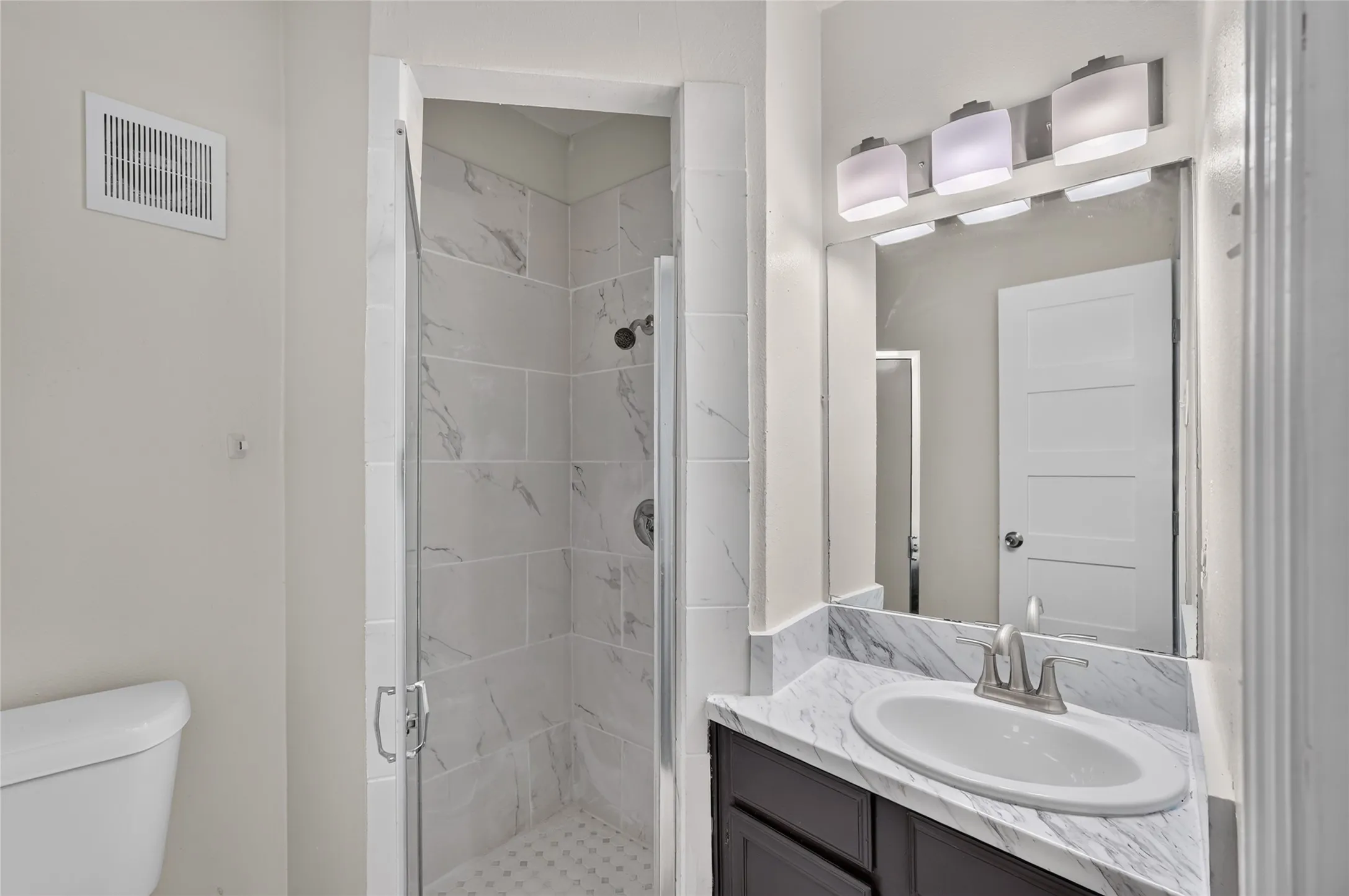 Shower with clear glass enclosure and tiled walls