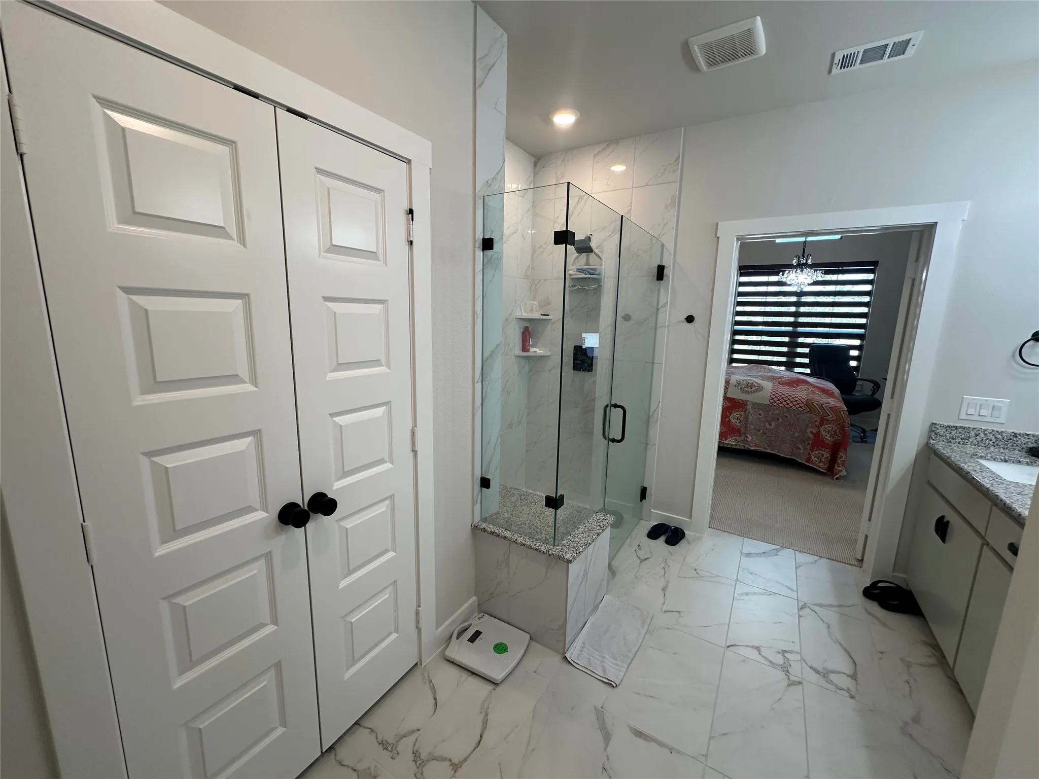Walk-in shower with clear glass enclosure and built-in bench