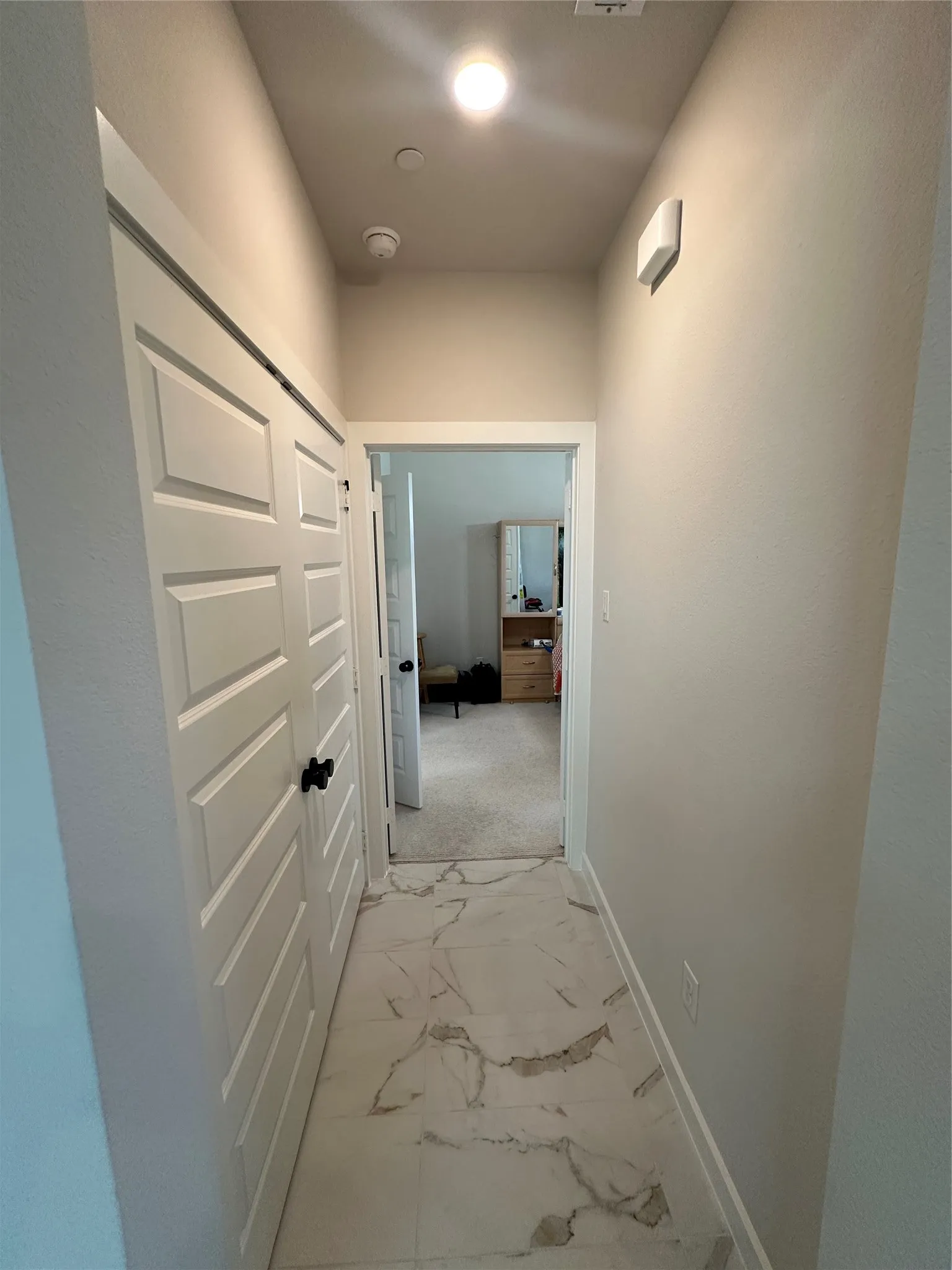 Hallway with patterned tile flooring, white paneled doors, and recessed lighting