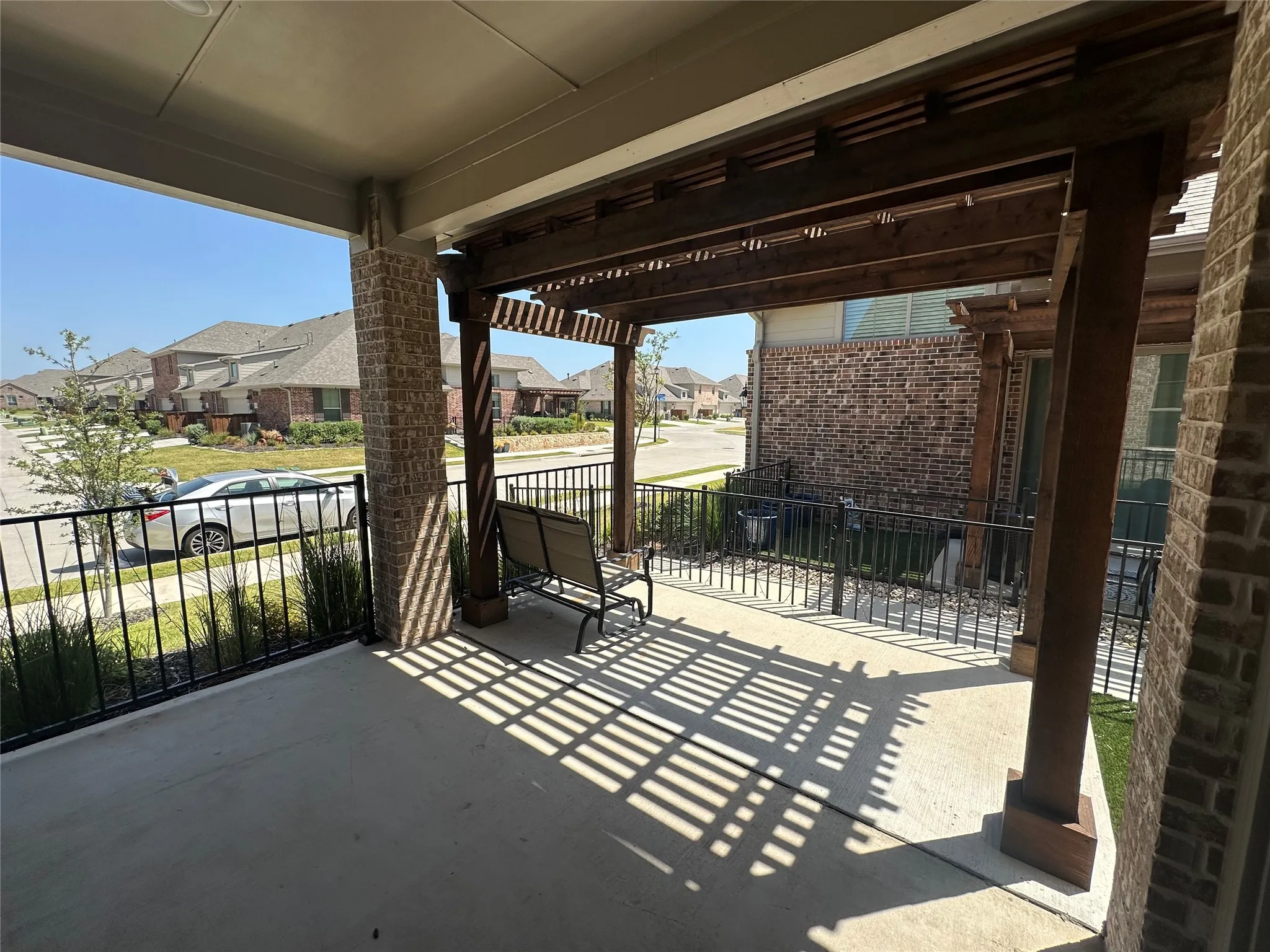 Covered front patio featuring a wood-finish pergola