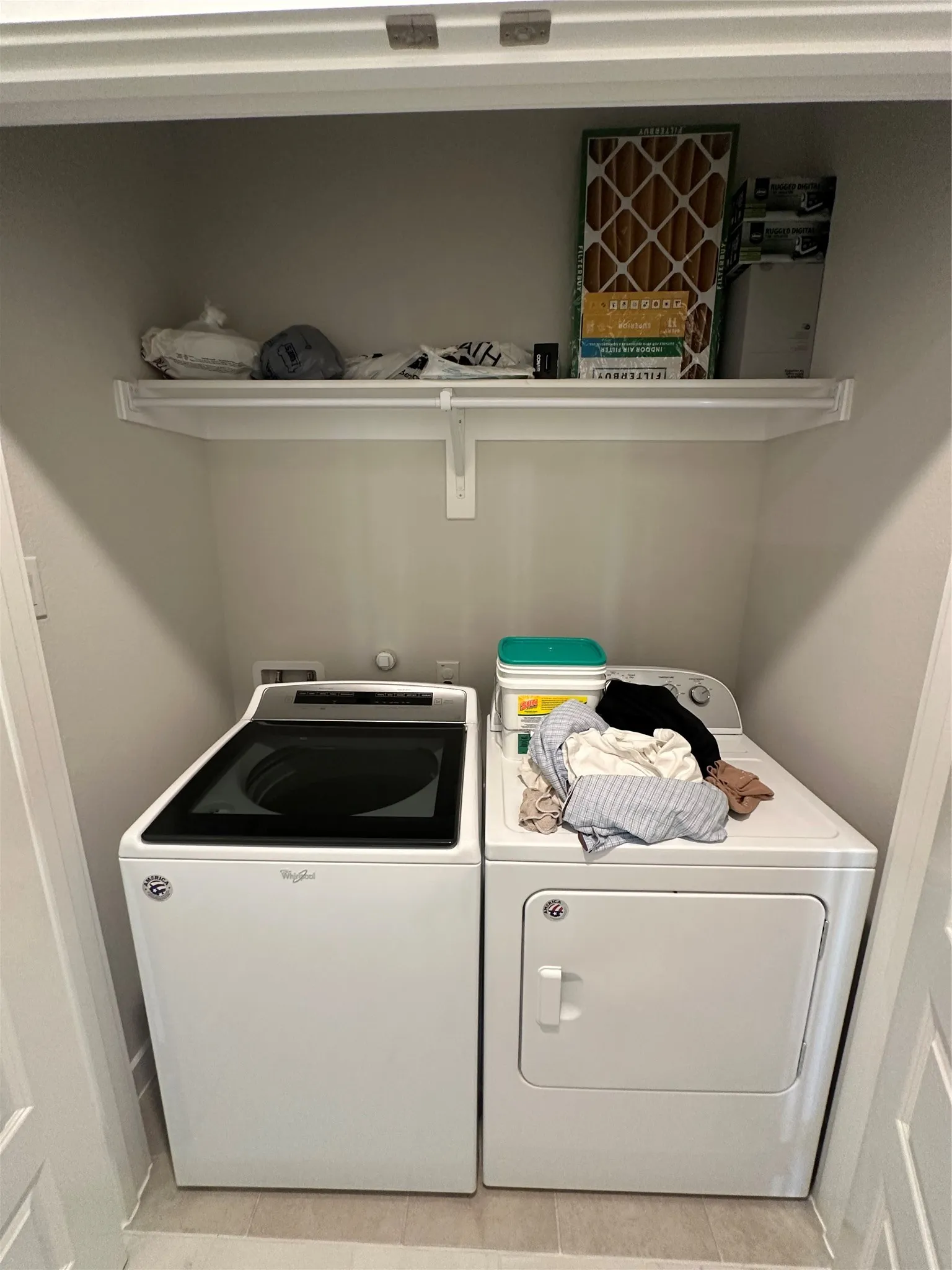 Laundry area with a white top-load washer and white dryer