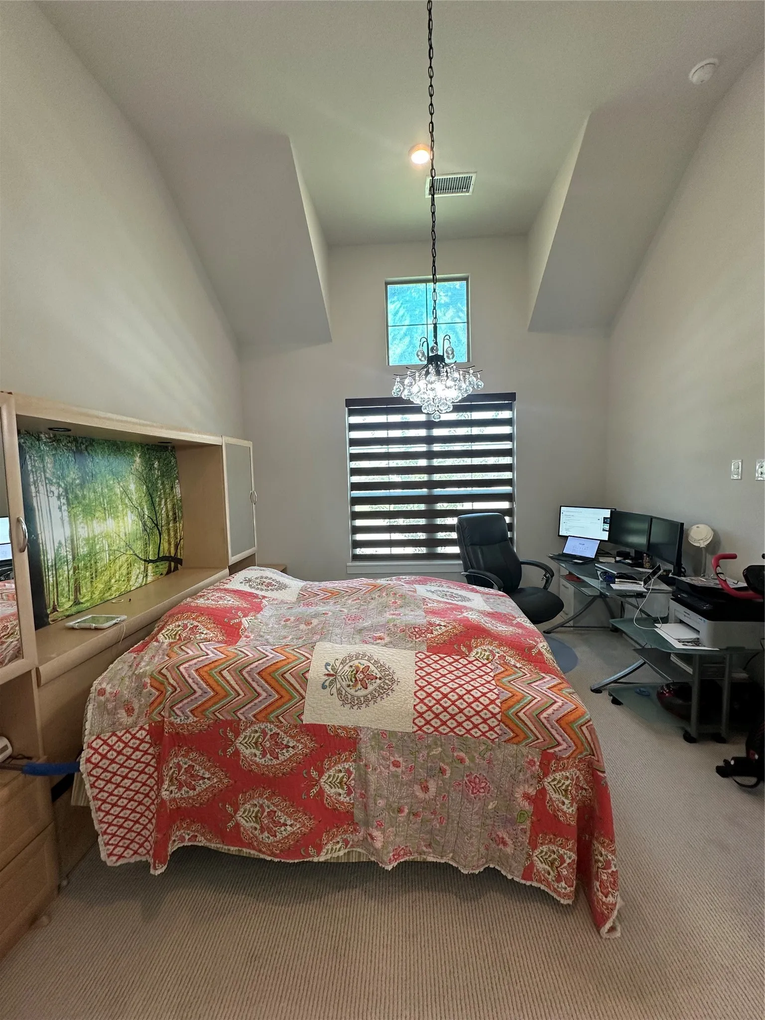 Vaulted ceiling featuring a decorative chandelier, upper transom window, and horizontal window blinds