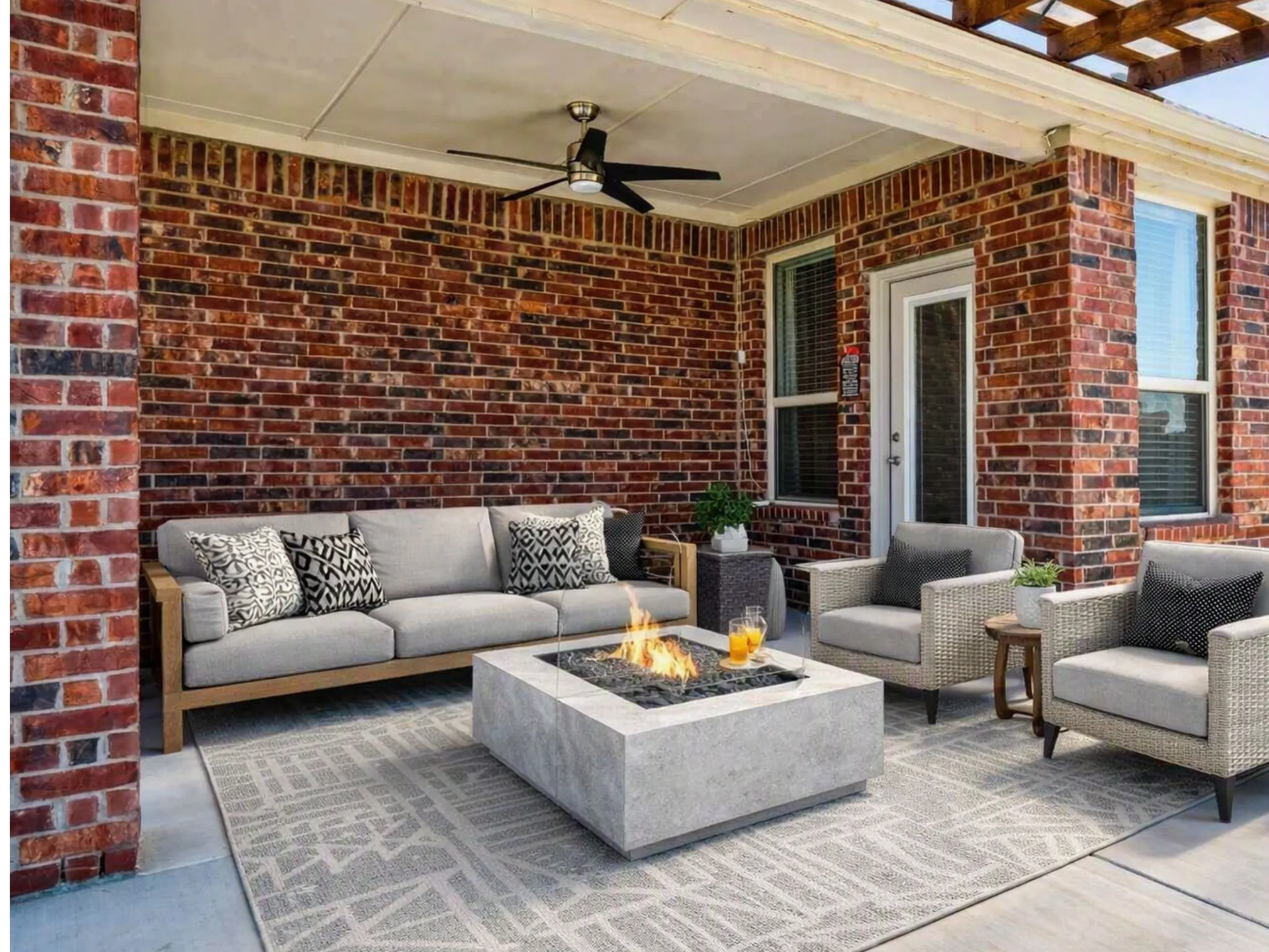 Virtual Staging for outdoor area - Covered patio featuring a ceiling fan, brick exterior walls, and a built-in fire pit