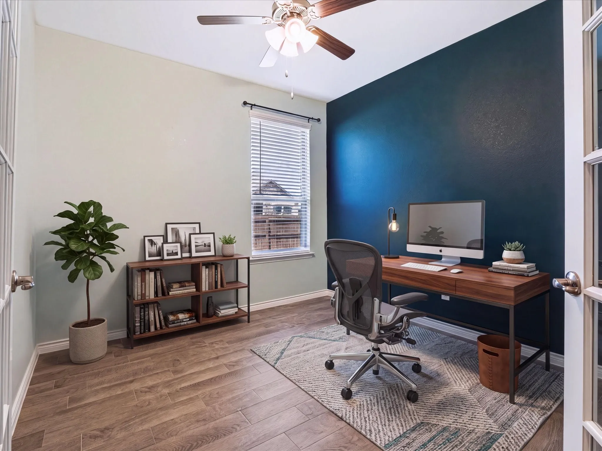 Wood-finish flooring, ceiling fan with integrated lighting, window with blinds, and a contrasting accent wall