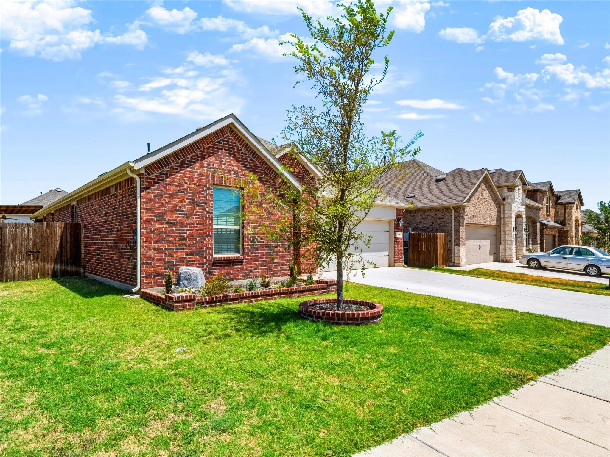 Brick exterior with a gabled roof, a front window, and an adjacent driveway