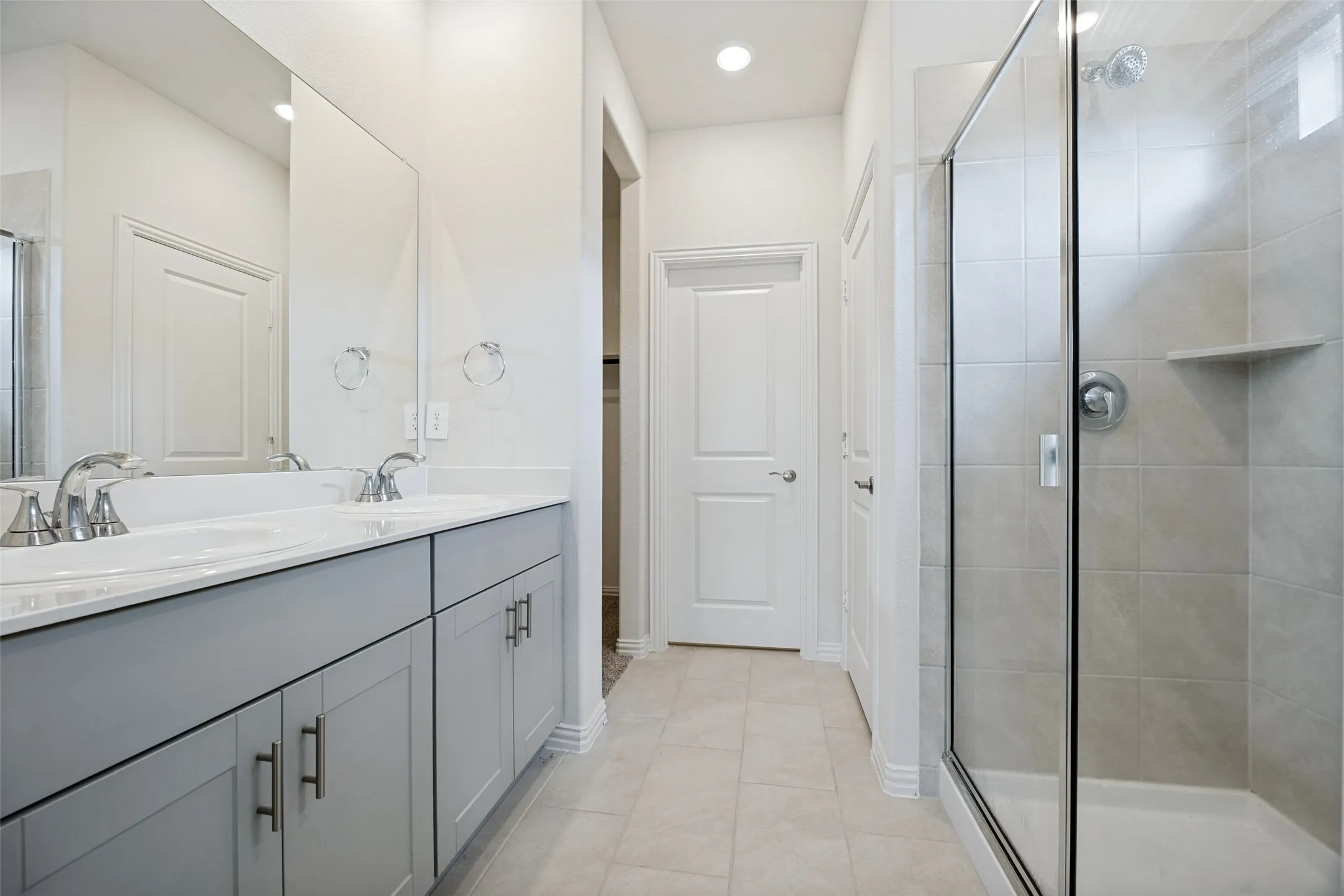 Relaxing Primary bathroom has double vanity sinks with a beautiful stand-in shower and leads to your enormous walk-in closet