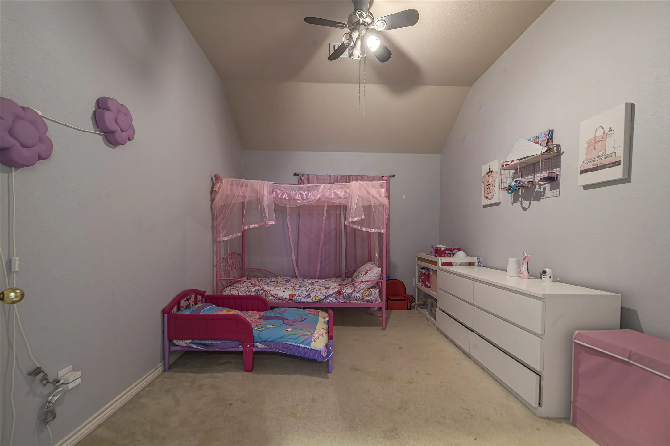 Vaulted ceiling, ceiling fan with integrated lighting, wall-to-wall carpeting, and light-toned wall finishes
