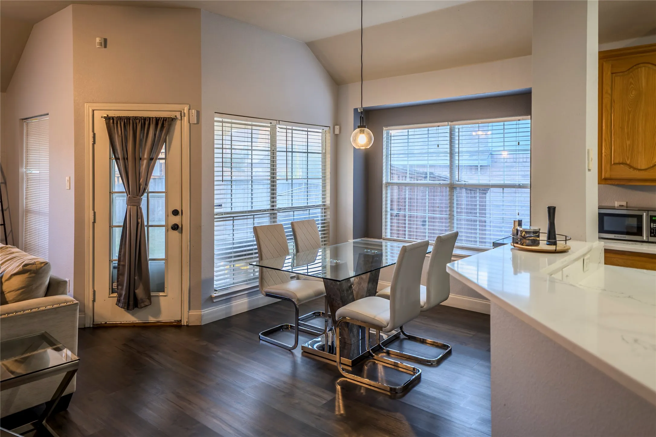 Vaulted ceilings, wood-finish flooring, and a glass-top dining table