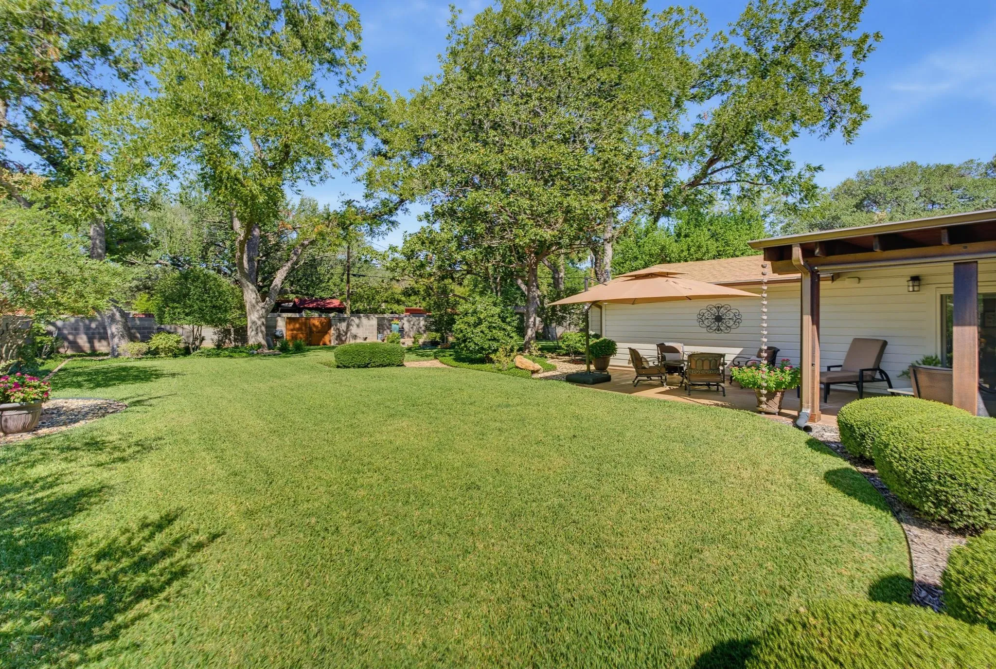 Expansive lawn with established trees and manicured shrubbery