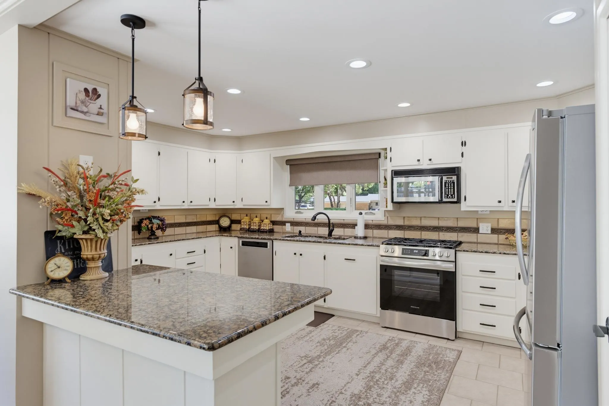 Kitchen featuring white cabinetry, granite countertops, stainless steel appliances, recessed lighting, and pendant lighting
