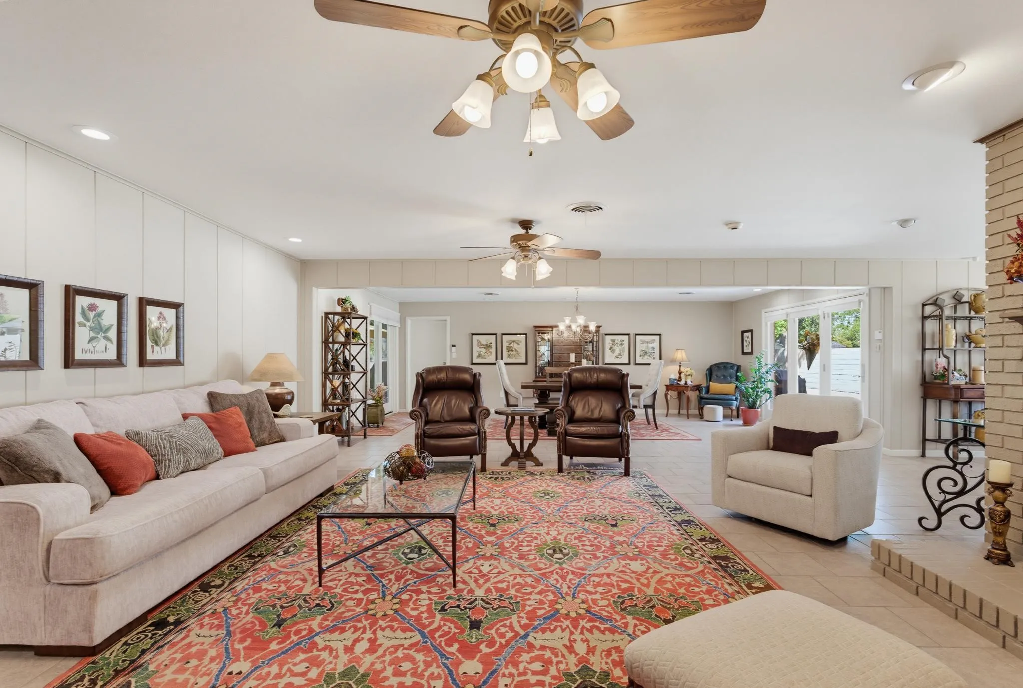 Recessed lighting, ceiling fans, and light-colored panel walls