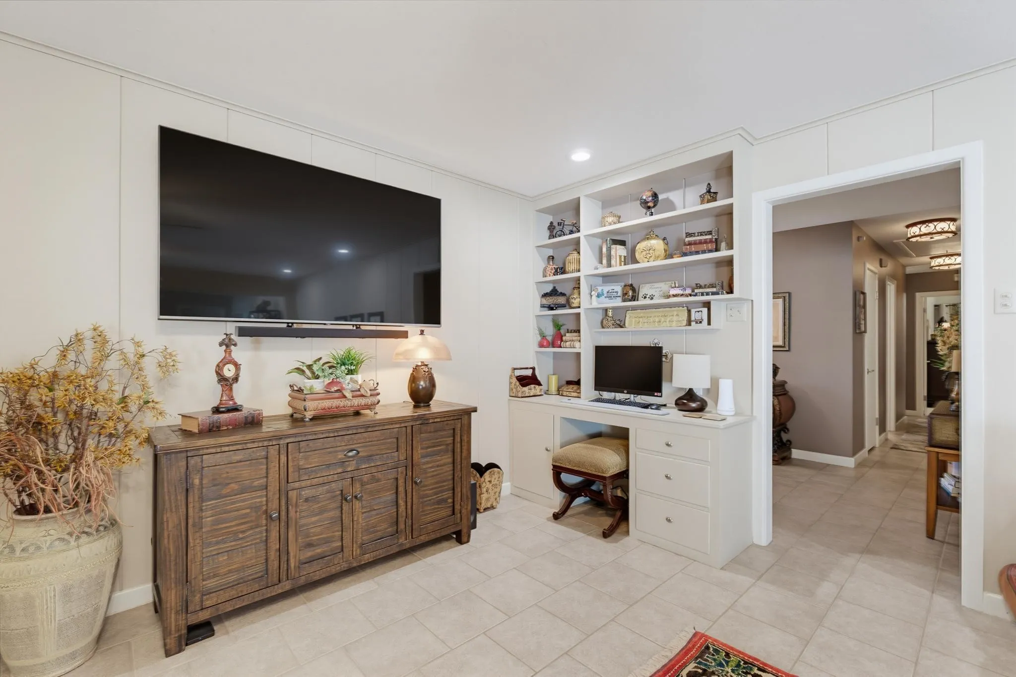 Built-in desk with integrated shelving, recessed lighting, and tile flooring