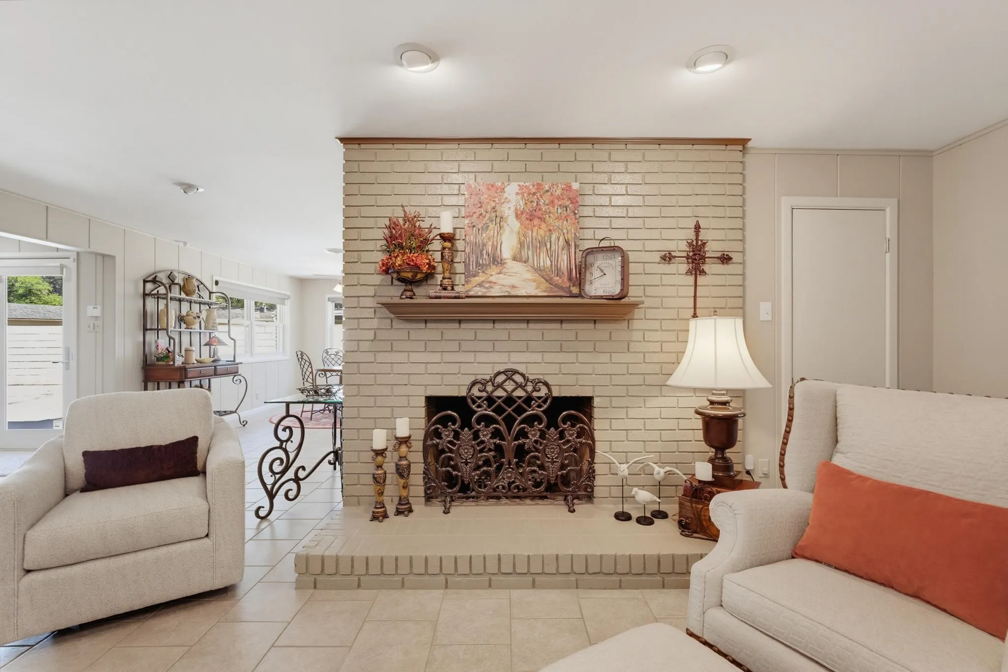 Brick-surround fireplace with a hearth, wood mantle, and decorative metal screen