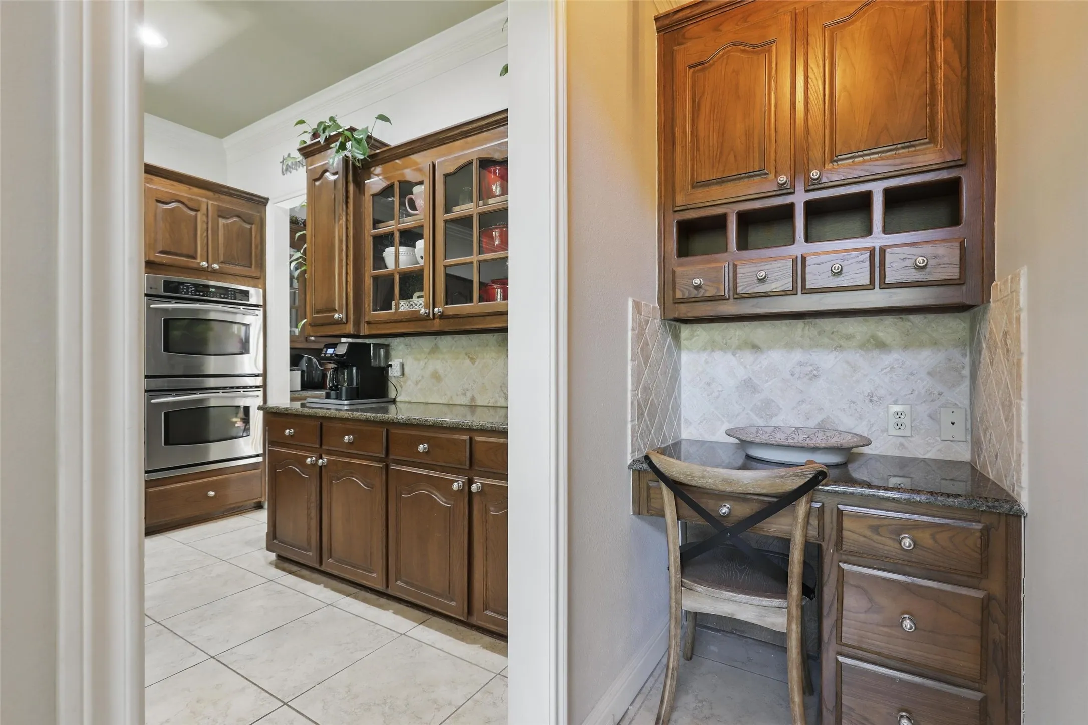 Kitchen featuring wood cabinetry, stainless steel double ovens, and granite countertops