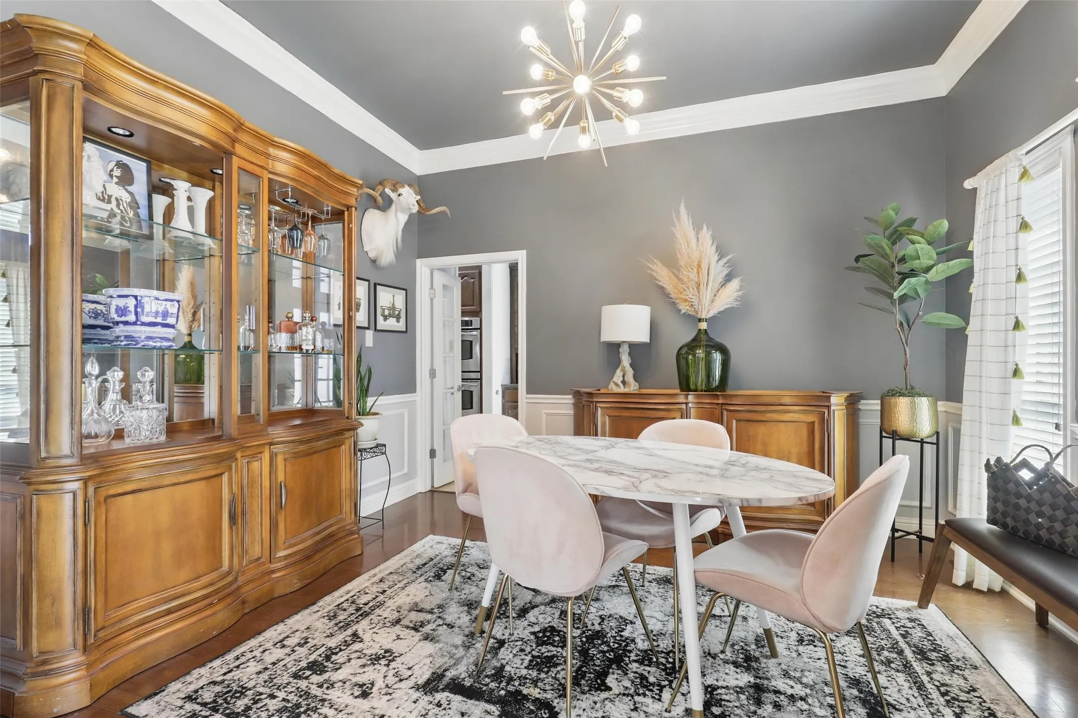 Dining area featuring a contemporary sputnik chandelier, crown molding, and wood-finish flooring