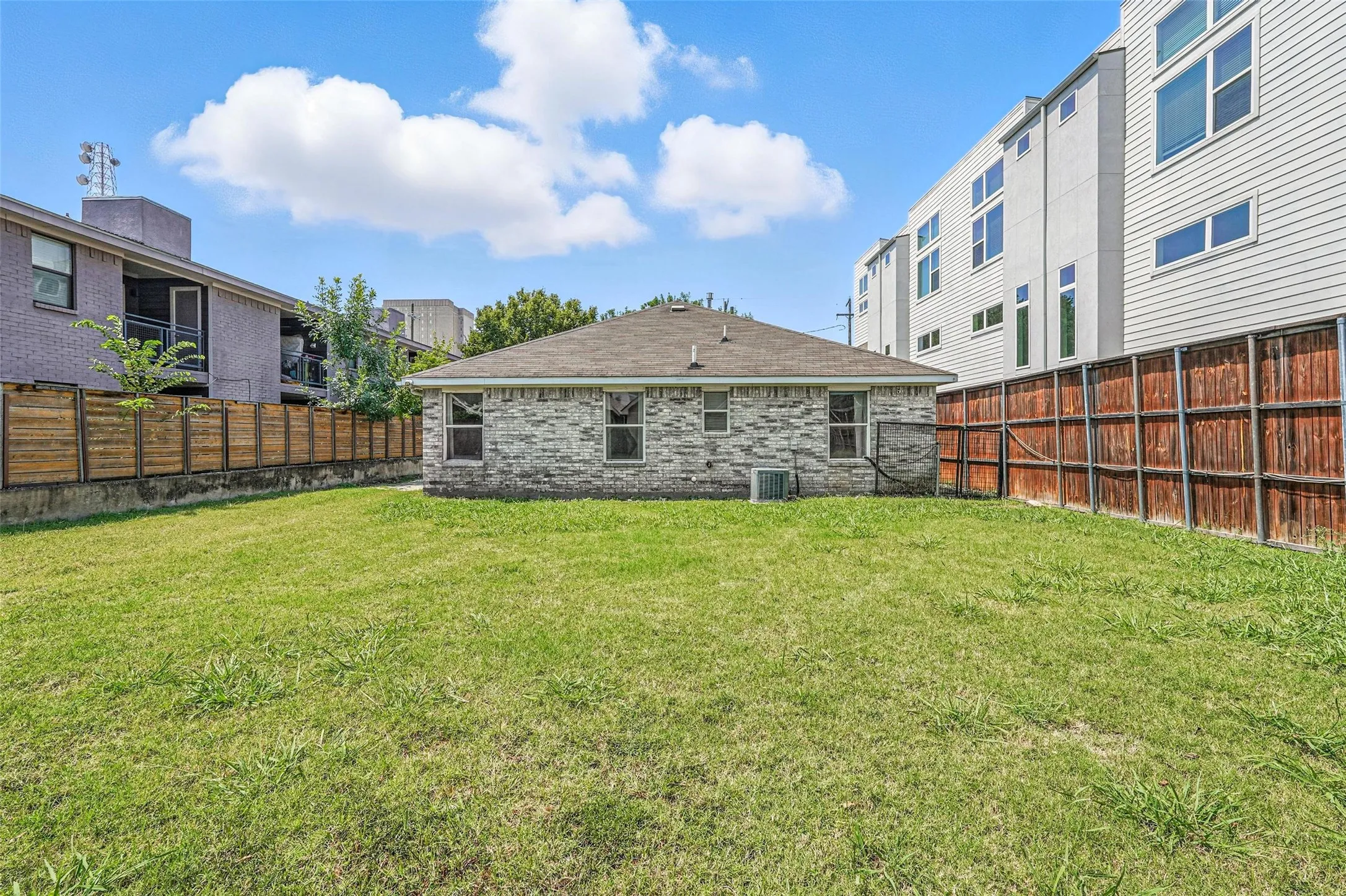 Back of house with a fenced backyard and a shingled roof