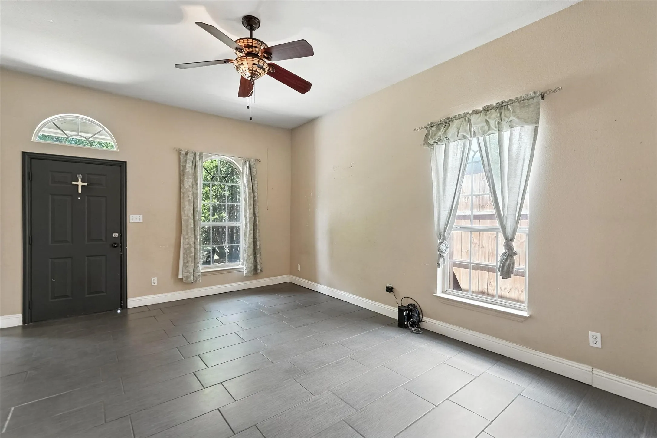 Foyer entrance with baseboards and a ceiling fan