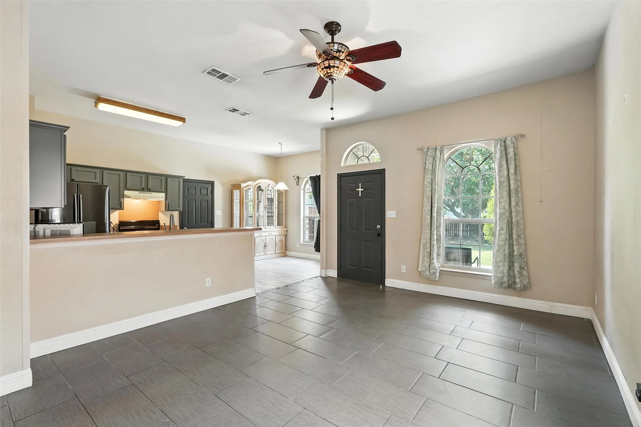 Unfurnished living room with ceiling fan and arched walkways