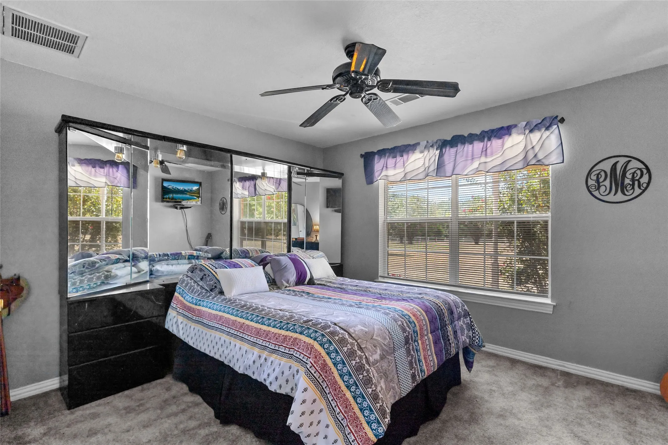 Window with horizontal blinds, ceiling fan, mirrored closet doors, and carpeted flooring