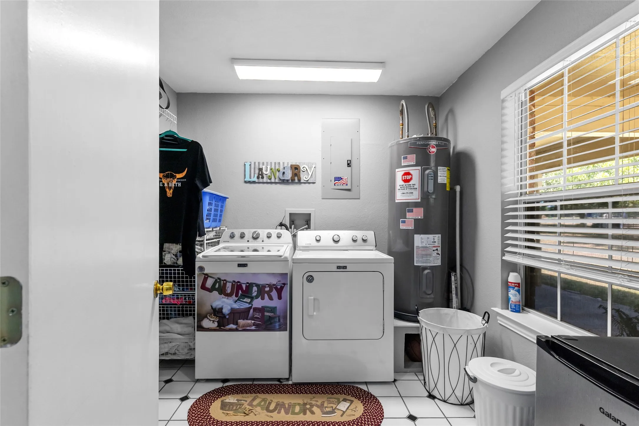 Laundry area with a window, white tile flooring, and integrated shelving