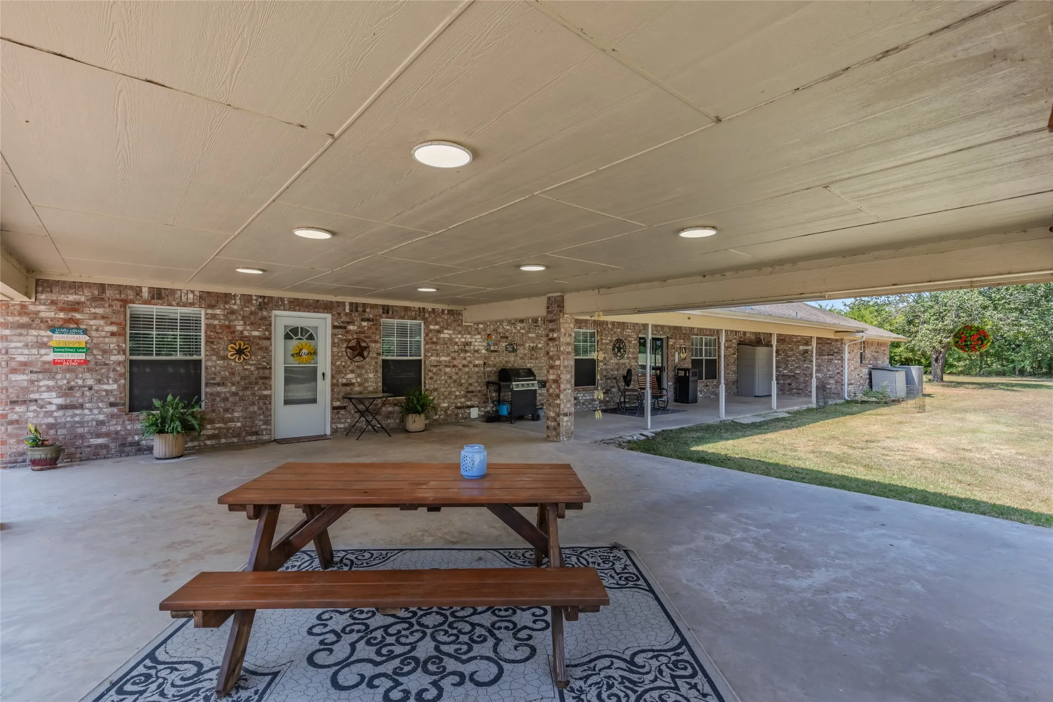Expansive covered patio featuring brick exterior, recessed lighting, and a concrete surface
