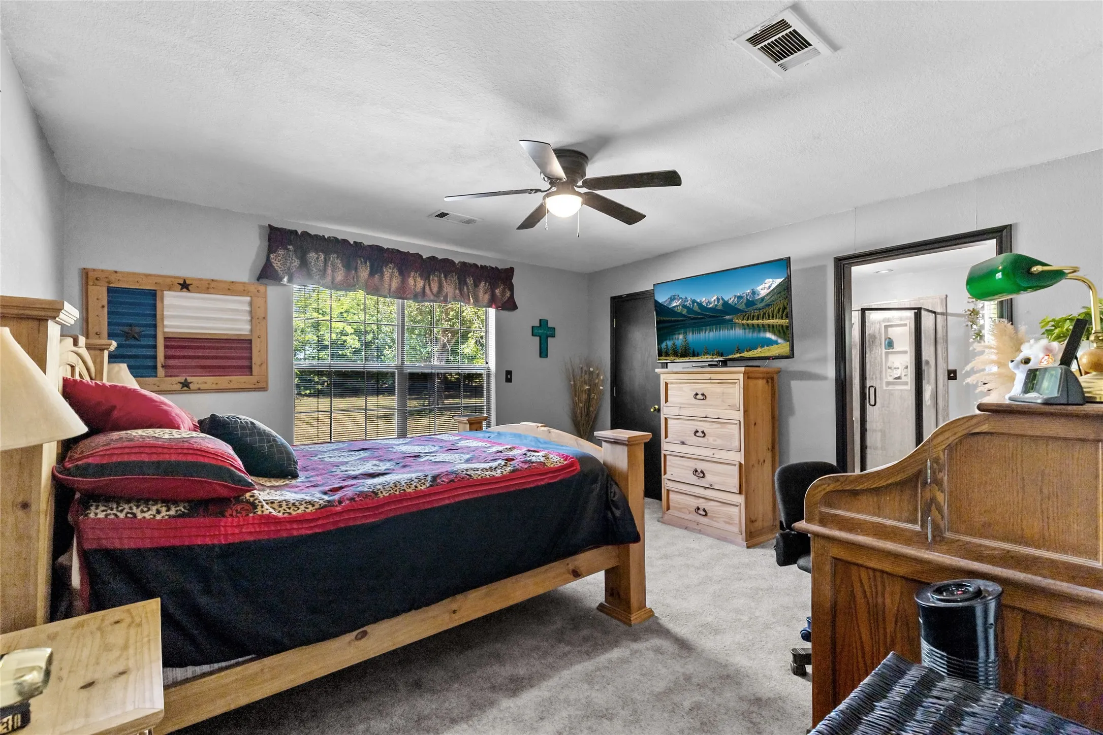 Spacious room featuring carpeting, a ceiling fan with integrated lighting, and a large window