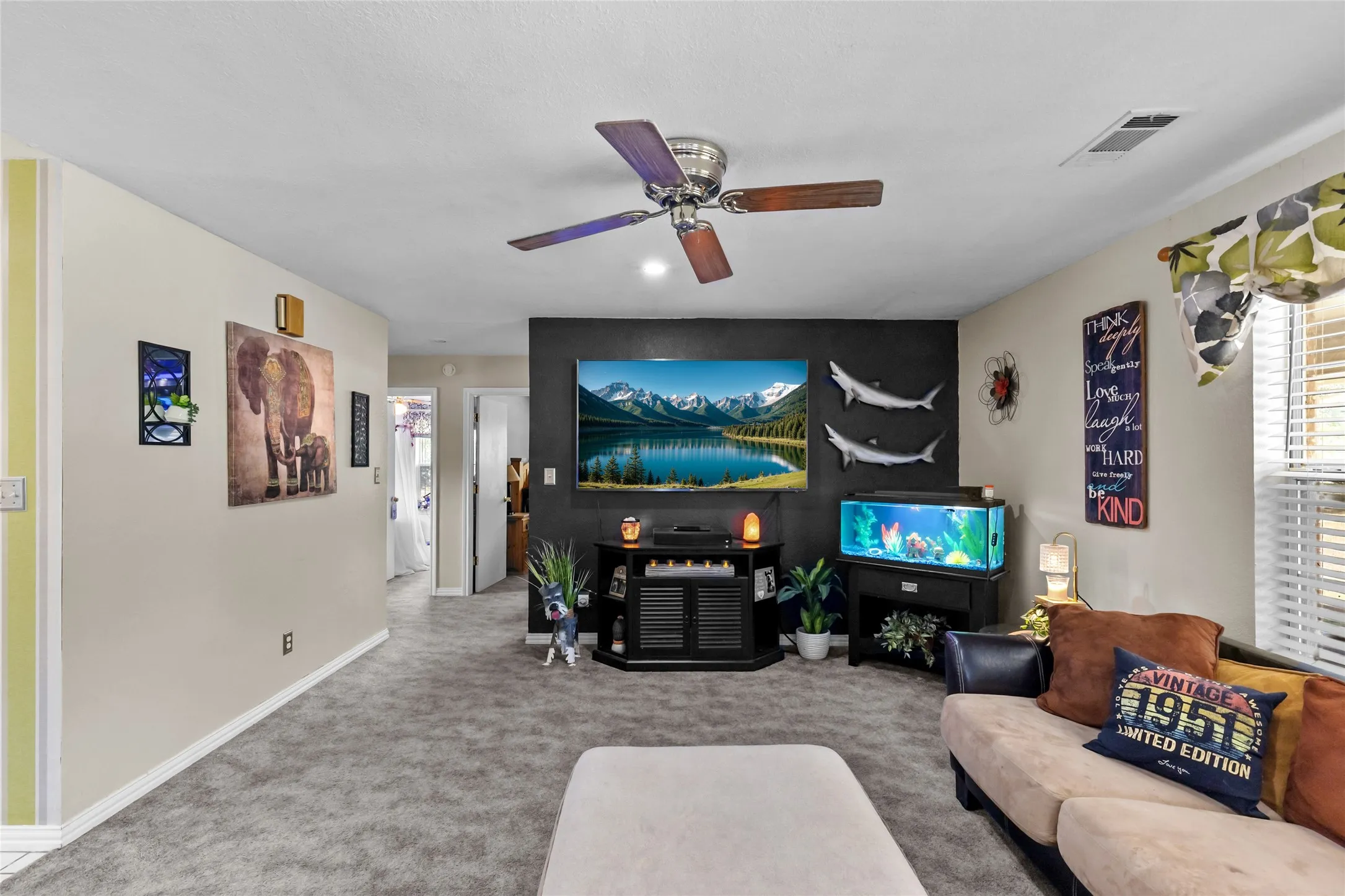 Wall-mounted television with media console, recessed lighting, ceiling fan, and carpeted flooring