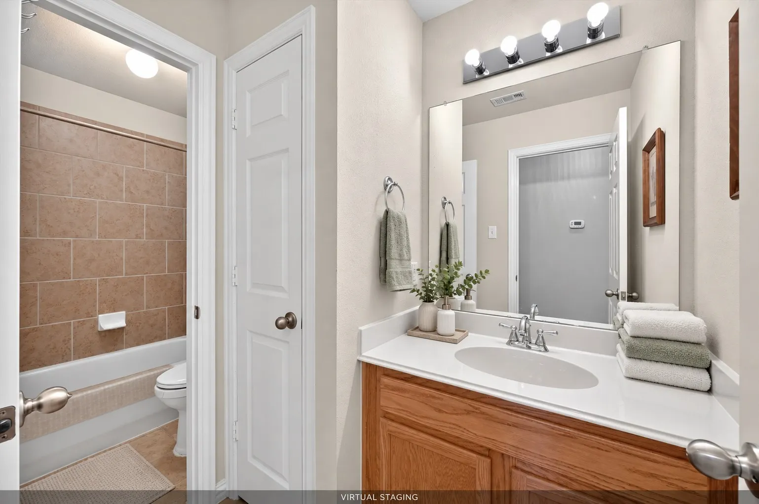 Upstairs bath features a separate vanity area from the bathing and lavatory space, plus a full-size linen closet for added storage.