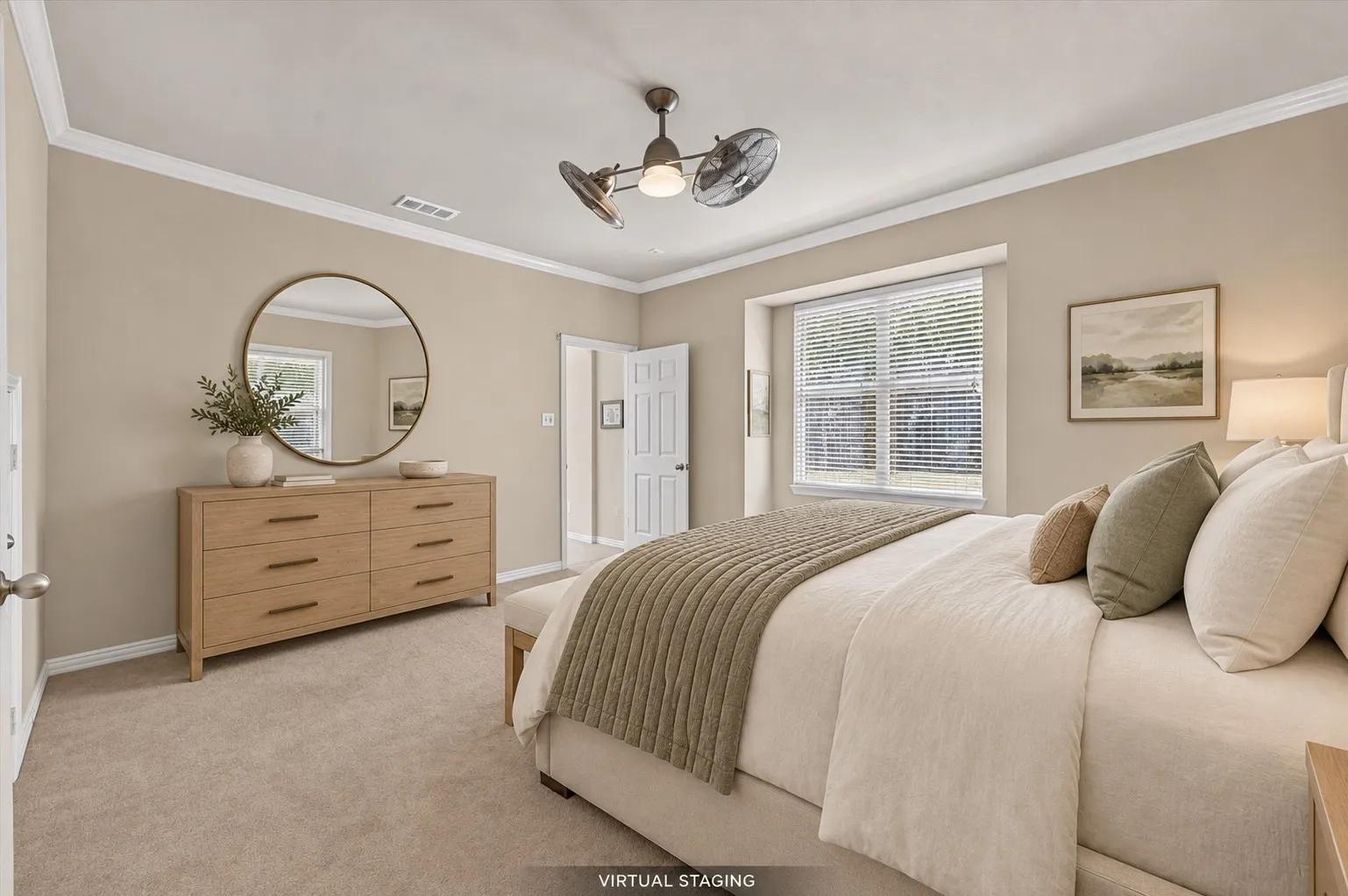 Spacious primary bedroom featuring a recessed window with built-in window seat, crown molding & neutral tones.