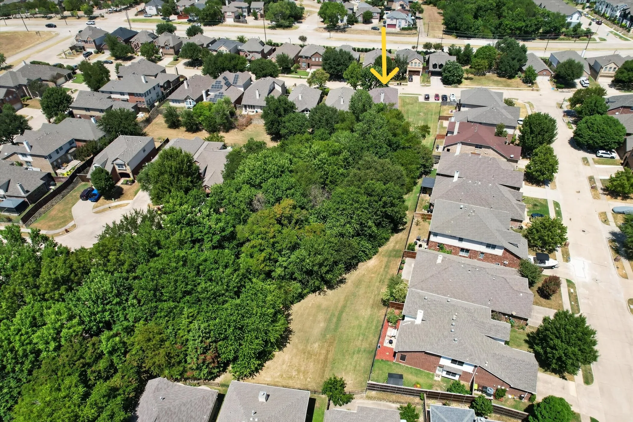 This aerial view showcases the expansive greenbelt area bordering both the side and back of the home.