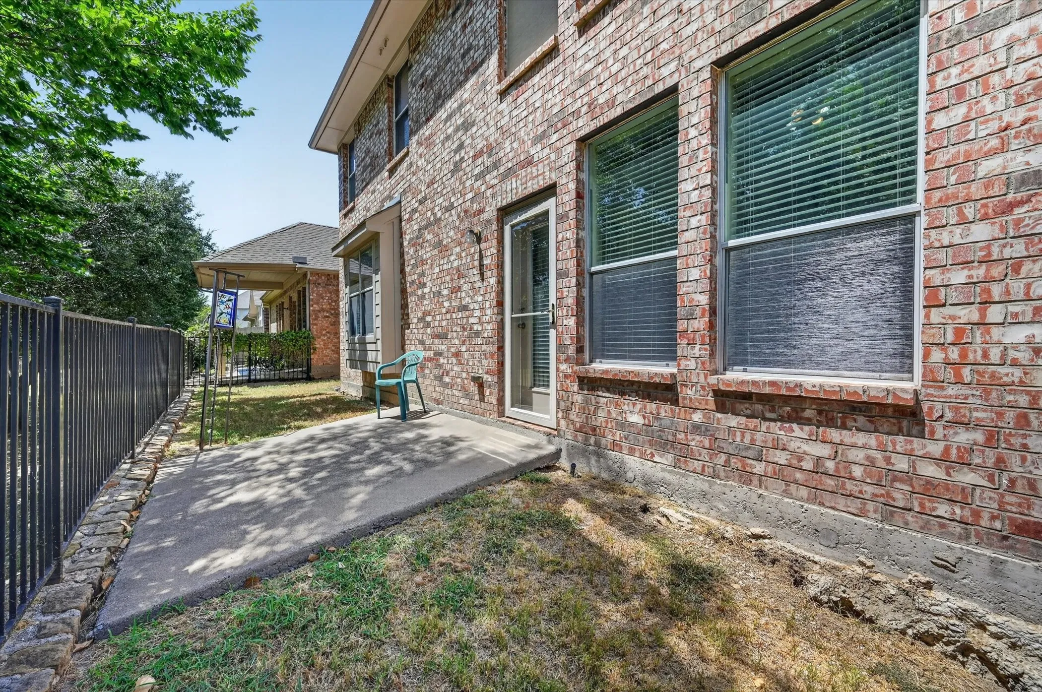 The backyard is shaded by mature greenbelt trees and features wrought-iron fencing, creating an open feel while allowing you to enjoy the natural surroundings.